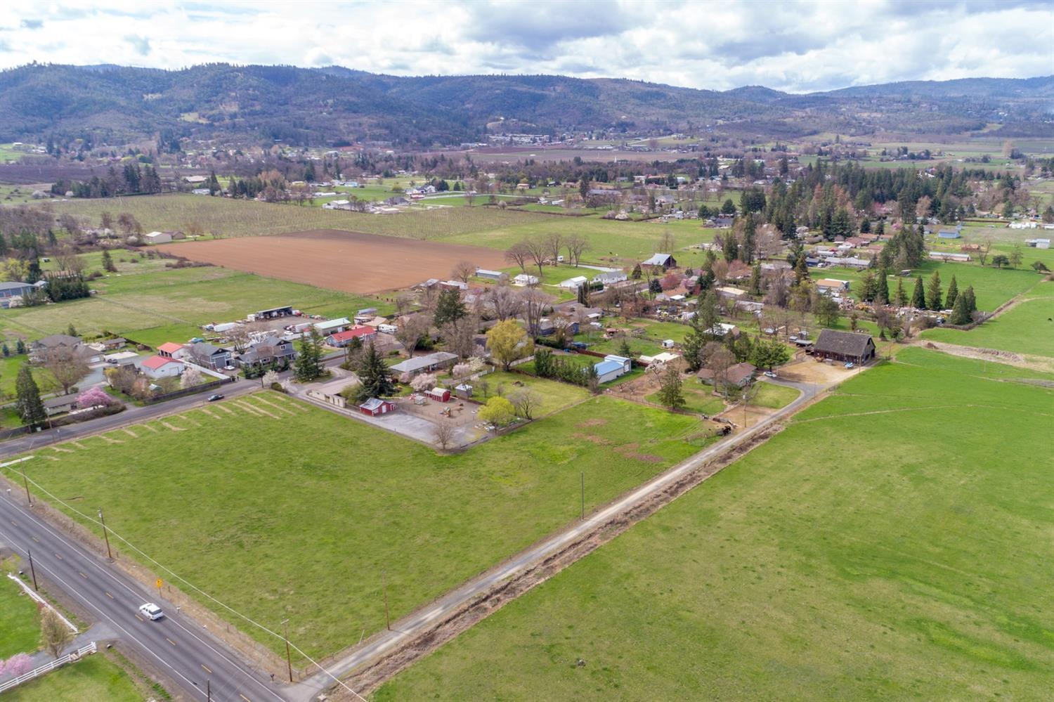 This one of a kind property w/ MID irrigation rights located minutes to Jacksonville transports you back in time. Whether your dream is a family farm, vineyard, or room for animals, this property has so many opportunities. The property consists of 2 separate legal EFU zoned parcels; the home parcel is set back from the road w/ 1.32 acres & has an additional 3.75 acre parcel adjacent to Oak Grove. The single story mid-century modern ranch style home is set far off the road & has been lovingly cared for by the present owner for many years. It has vaulted ceilings in the large living room, a fireplace & lots of windows for natural light & views of Table Rock. The original kitchen appliances are in pristine condition. It has 2 fenced pastures for cattle or horses, an incredible barn from the early 1900s complete w/ a resident barn owl & a huge parklike backyard for family entertaining. Come see the variety of pasture, fruit trees, & garden area that make this property so amazing.
