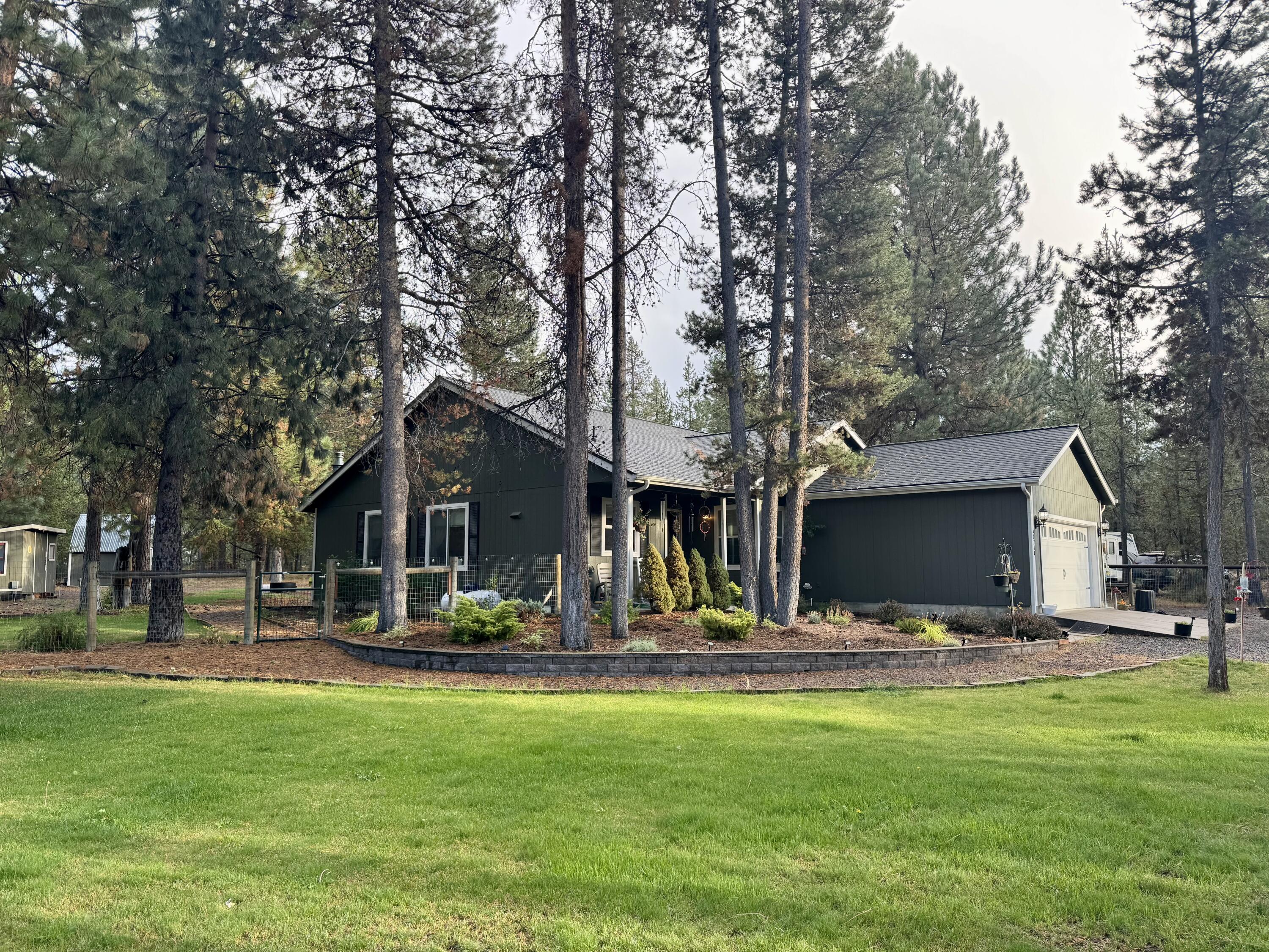 This 1,531 square foot home, built in 2002, features four bedrooms, two bathrooms, and an attached garage with ample storage. Interior highlights include laminate flooring, carpeted bedrooms, vaulted ceilings with ceiling fans, and a propane fireplace in the living room. The heat pump offers both heating and air conditioning. The kitchen is equipped with granite countertops, stainless steel appliances, and a gas range. The primary bedroom features an en-suite bathroom with a walk-in tiled shower. The home has a new roof installed in 2023. The 1.01 acre is fully fenced and landscaped yard includes front and back sprinklers and additional storage buildings.