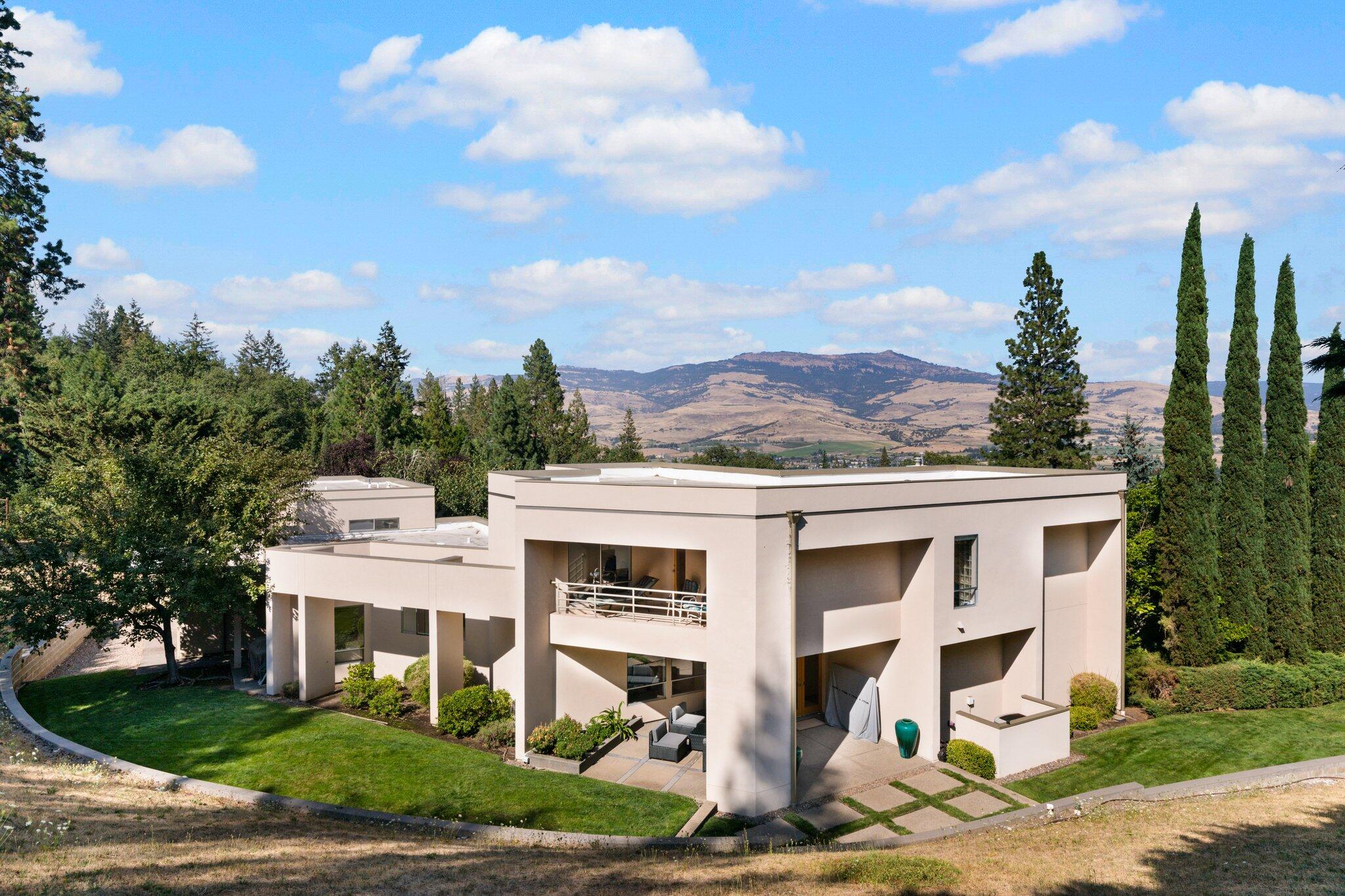 A magnificent Ashland estate is located above Lithia Park & the Plaza in a most desired location. Quality construction, exquisite attention to finishes and details, with extraordinary views of Grizzly Peak and Cascades. Large open living room has a gas fireplace and floor to ceiling windows. The primary bedroom is in its own complete wing. This includes a large primary bedroom, den/office and a master bathroom with a spa tub and glassed in shower and patio. The second wing has 2 bedrooms and 1 bathroom. The gourmet kitchen has a breakfast bar, an informal eating area which leads directly to the outdoor patio. The formal dining room can accommodate 6 or more guests. The kitchen has extensive cabinetry and counter space, high end stainless steel appliances and a gas stove. The main level has an extra room which has a queen sized Murphy bed and can be a den, TV, gym or whatever. This 1 acre gated estate gives you privacy while being close to the restaurants, theater and the park.
