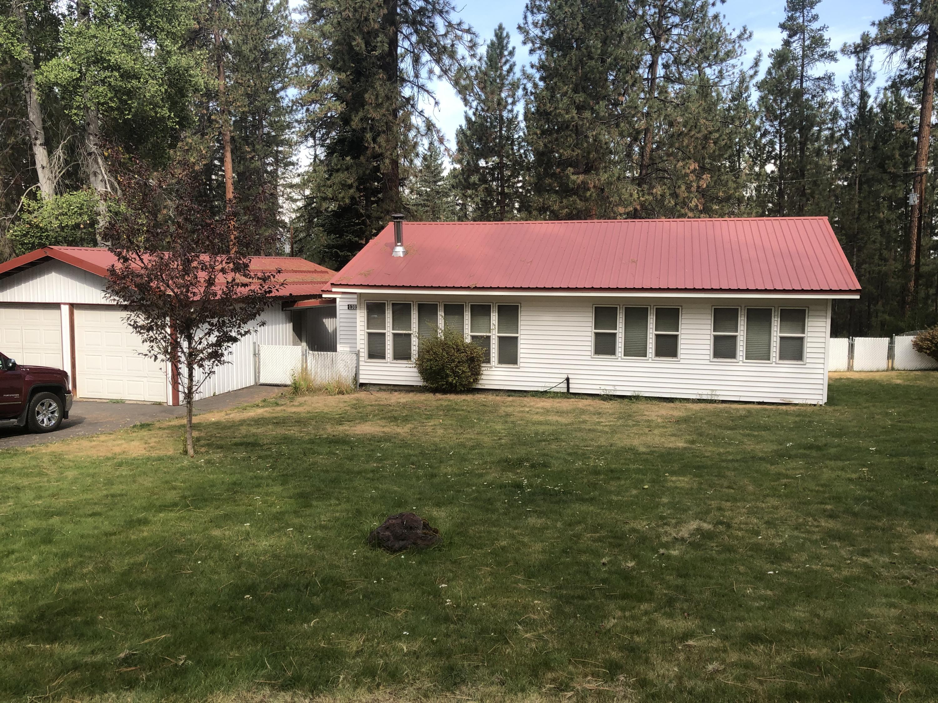 This 3 bedroom home sits on .51 acres that borders forestland.  Lots of room for RV parking, or an RV garage.  2 car garage with large double garage size workshop attached in the back, plus  a large 1 car garage/storage shed for all those extras.  Underground sprinkling system, large deck in the back, vinyl siding and metal roof makes maintenance low.  This home has been totally refurbished.  Totally, New kitchen, appliances, flooring, bathroom, furnace, lighting, and much more.  Must see to appreciate.