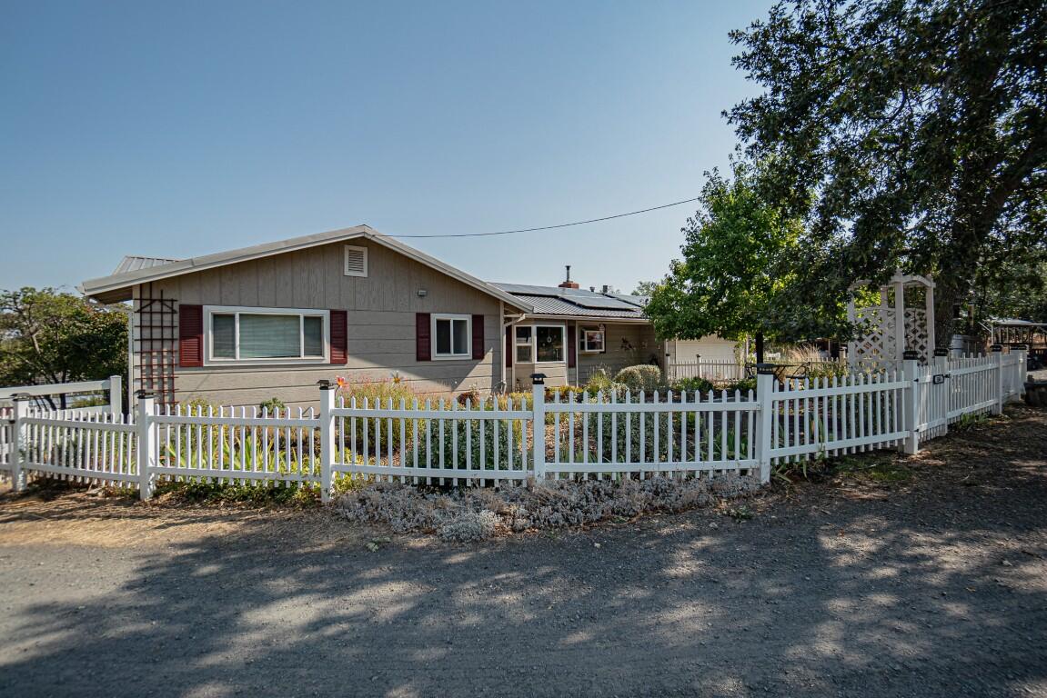 Charming one-level hobby ranch home on 6+ usable acres, perfectly situated on a level knoll for privacy and views! The comfortable home has been nicely updated with newer kitchen cabinetry and counters, cozy eating nook with bay window, spacious living with fireplace/insert, updated view windows for light and bright interiors, a sizable primary bedroom, guest bedroom and office, 1-1/2 baths, plus two slider-doors to access the big, north-facing deck overlooking raised-bed gardens, water feature and serene rural landscapes! This is a super horse setup too, with 60x120 arena, 2-stall barn, hay storage, tack room, detached 600 square foot ranch hand quarters with new roof, full bath and Monitor heating & A/C, storage buildings, pole barn & fenced pasture areas.  Includes a sizable double garage, metal roof, 24-panel solar array, huge rain-catchment water storage system, brand new septic system, fresh topped driveway, & great treed setting that's peaceful and quiet!
