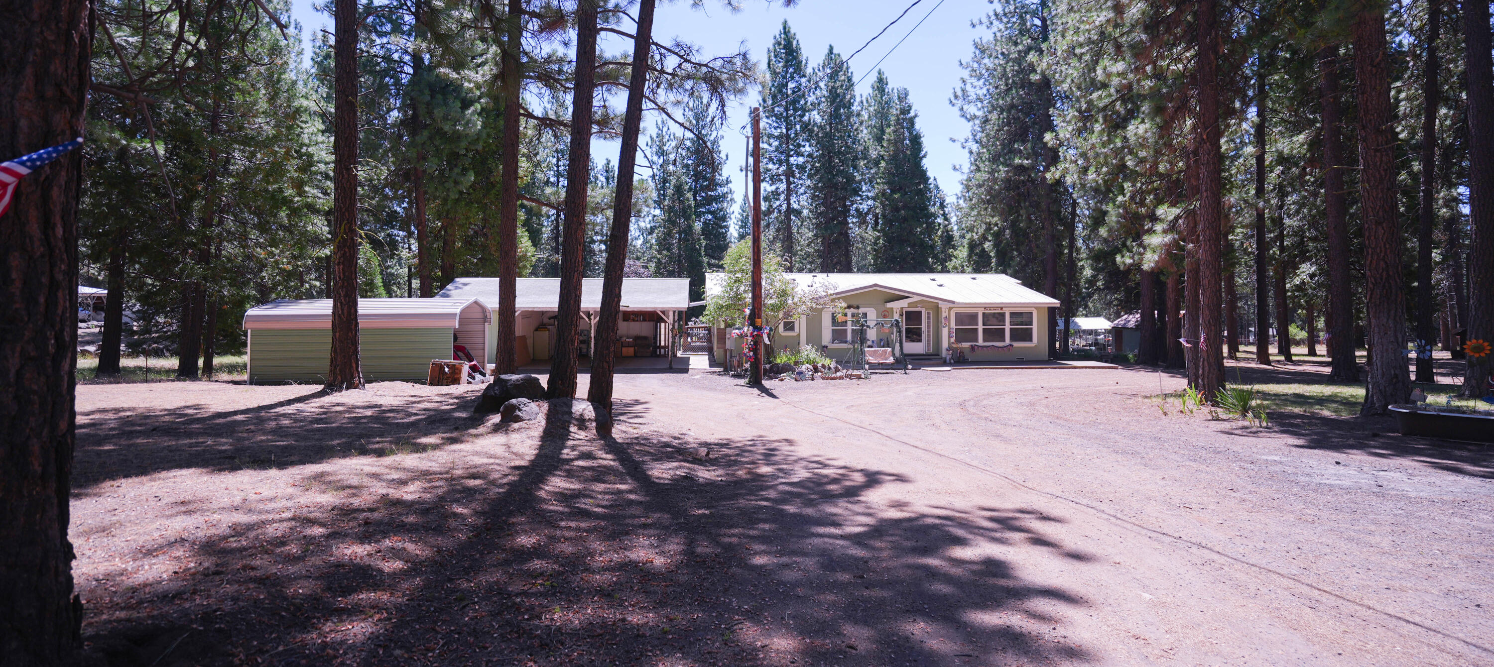 Charming 3-bed, 2-bath home on peaceful 1.54-acre property with a bonus 1.46-acre lot ready for a second manufactured home—utilities already installed! The yard features underground sprinklers, a spacious deck, & a thriving garden. Towering pines offer privacy & shade. Perfect for entertaining, enjoy the outdoor BBQ area & a second living room inside for added comfort. Multiple outbuildings provide generous storage, plus a 2-car carport, tractor storage, & a cozy outdoor craft room with pellet stove. Endless potential—schedule your showing today! New Well Pump and Wiring 07/2025. Seller offering $3,000 Credit to buyer for flooring. Seller will be fixing the air conditioner and adding a dishwasher.