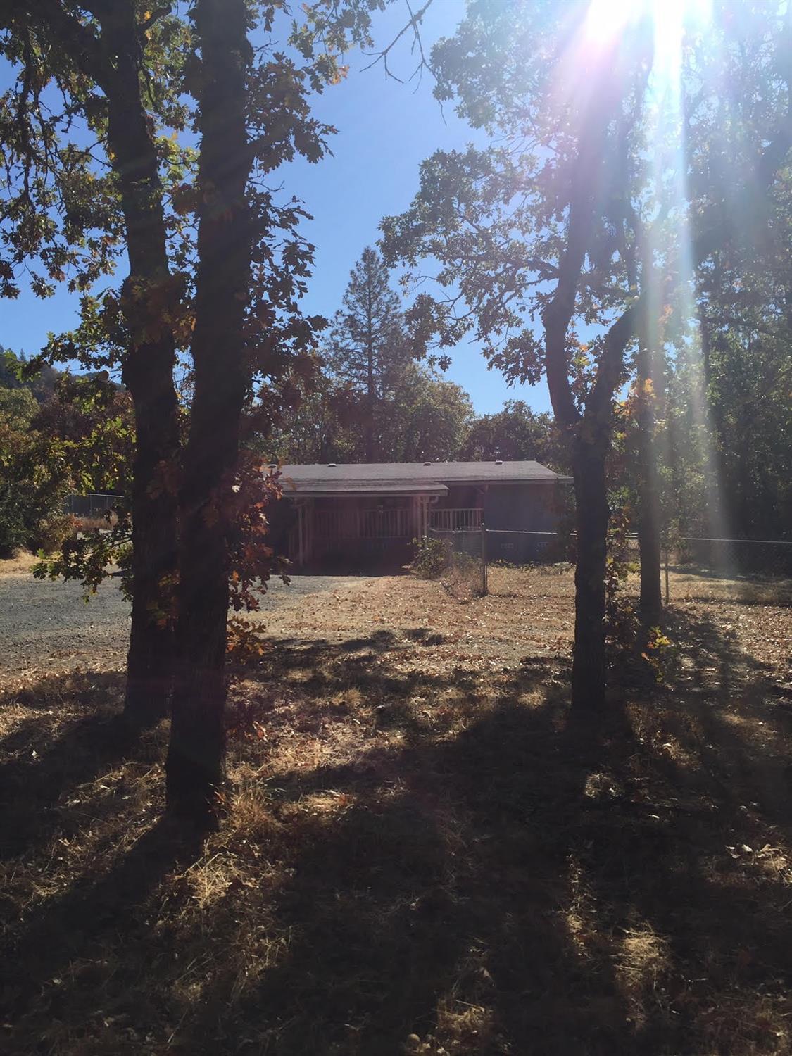 Great opportunity for country living on a acre of land super close to town! Large carport, fenced dog yard, out buildings and lots of beautiful trees. Great views and just minutes from amenities. This property may qualify for Seller Financing.