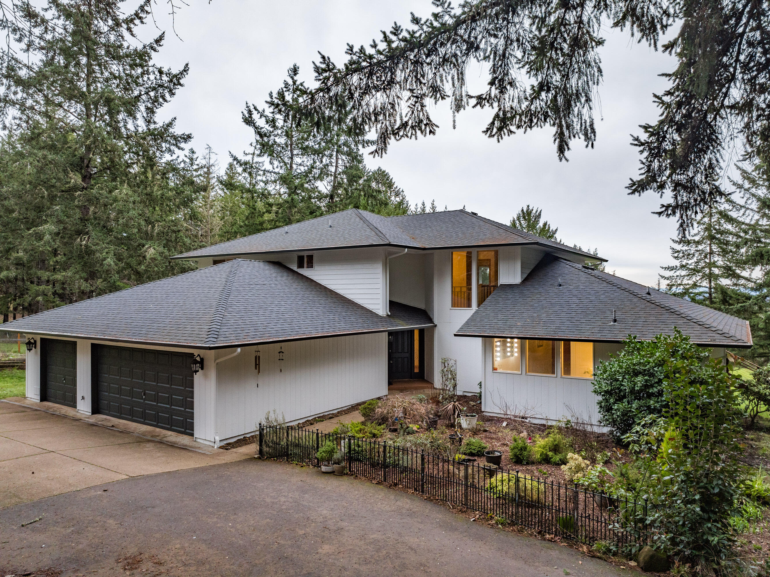 Nested on 5 acres, this charming retreat boasts a tree-lined driveway leading to a picturesque haven. Enjoy panoramic views of the Three Sisters Mountains from your large redwood deck. The mature trees, blueberries, and fruit trees create a private paradise, complemented by a fenced garden, chicken coop, and storage shed. Explore walking trails amidst nature's beauty. With 4 bedrooms, 2.5 baths, a spacious bonus room, and an office, this home caters to every need. The master suite features a huge walk-in-closet and spa like bath. The updated kitchen showcases stainless steel appliances, quartz, and crown molding. A 3-car garage adds convenience, while being close to amenities and Peavy Arboretum ensures a perfect blend of tranquility and accessibility.