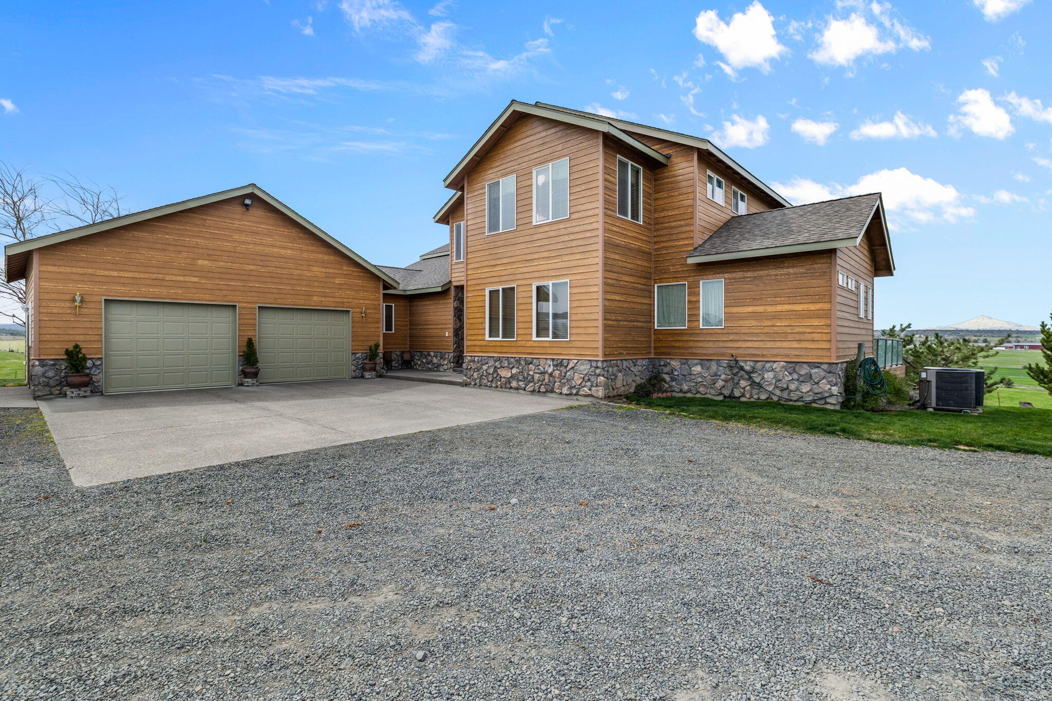This beautiful  5200+ square foot home gives the feeling of a traditional farm home with very modern amenitites. It features three primary bedrooms, two on the main floor, and an extra spacious one at the top of the elegant staircase.  An office space, also on the upper floor, is large and affords a view of the Cascades and the surrounding farm land that will rival anything in Jefferson County.  The large, open downstairs space provides for many possibilities, whether it be a craft room or a social gathering hotspot. There is even a bedroom and full bathroom downstairs making it the perfect guest room.  There is close to 1000 square feet of deck off of the main floor, which can serve as shade for the patio area off the bottom floor. This is a wonderful home that sits on 65+/- acres with over 60 acre feet of Deschutes Water Rights that are distributed through North Unit Irrigation. Finally, the property has a second 1300 square foot home currently rented to a long term tenant.