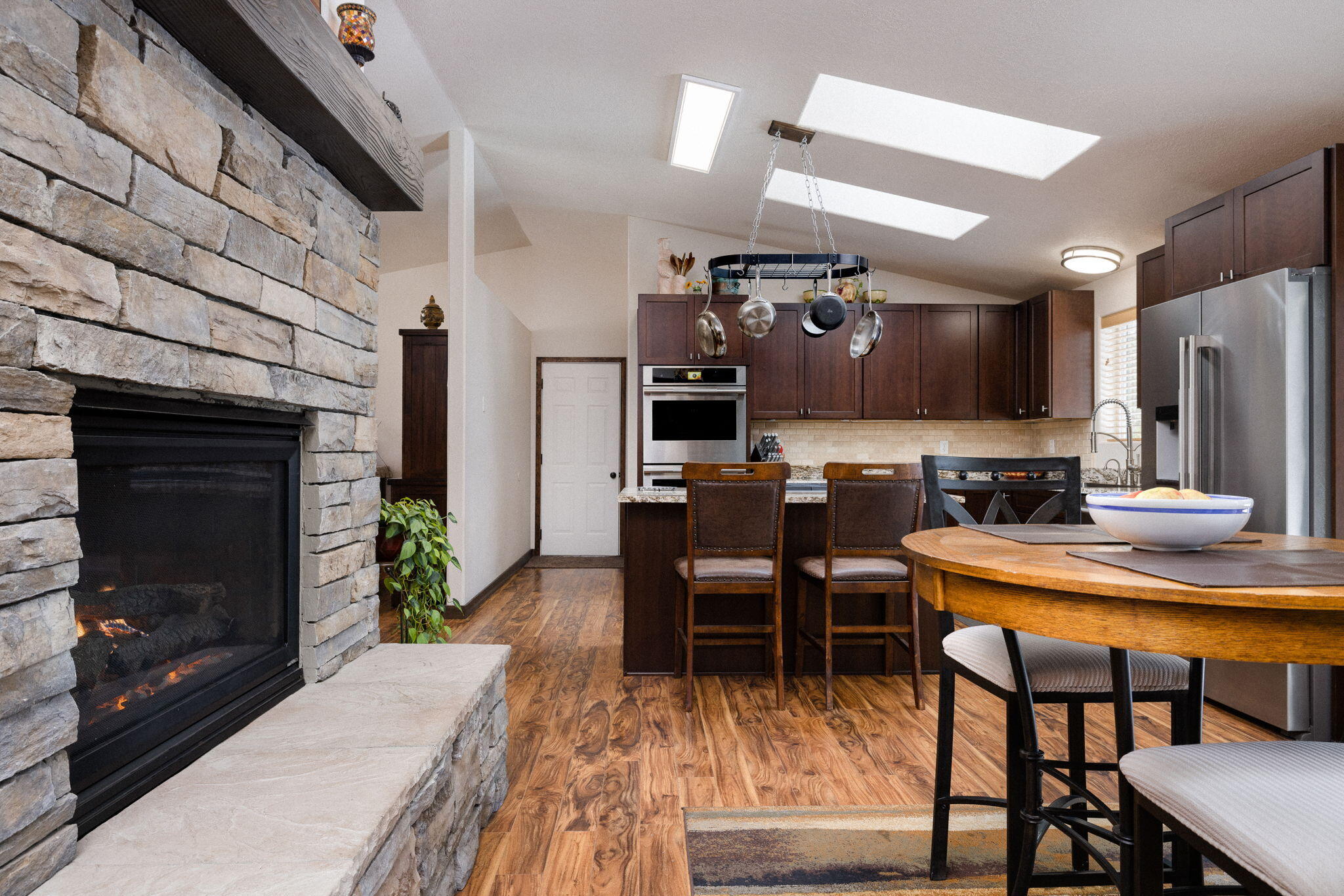 This stylish single level home has been beautifully updated with all the comforts and amenities you could ask for. Entering the home, you instantly get a sense of warmth and openness as the rooms fill with natural light from the high ceilings, spacious windows, and skylights above. A 2-sided stone fireplace separates the open living room from the gourmet kitchen and dining area, complete with granite countertops, stainless steel appliances, and a 300 bottle wine cellar. Enjoy 4 large BR and 3 BA, including a new primary bath that features a gorgeous glass steam shower, dual vanity sinks, and tile flooring. Spend time in 1200sqft heated and air conditioned multipurpose room, where you can relax and unwind away from the main living area. With a 3 car garage, 2 decks, covered carport, a green house, RV pad, and fully fenced area for your pets, this house has too many great features to list. Come visit and you'll see why you will want to make this your new home!