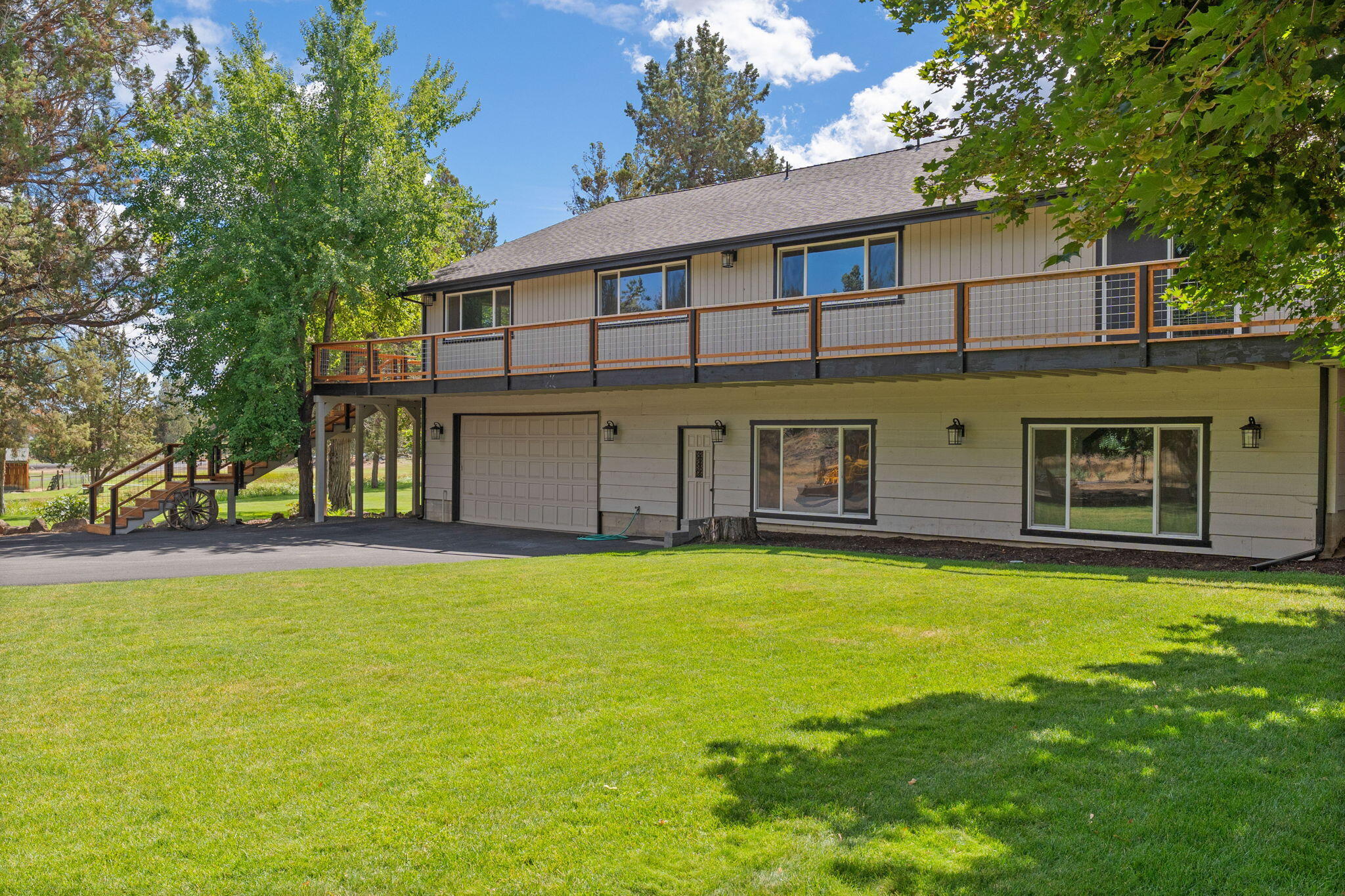 Just 9 minutes from the Eastside of Bend, this custom residence captures a balance of privacy & convenience. Offering 5 acres—w/ 2 acres of irrigation rights—the property backs to 145 acres of protected wildlife habitat. Designed for effortless main-level living, the upper floor offers 3 bedrooms + an office that could serve as a 4th bedroom. The heart of the home is the remodeled kitchen, featuring quartz countertops, updated appliances & tons of storage. An inviting vaulted great room with dramatic exposed beams & expansive windows create a light, peaceful space. The lower level offers many uses including a home theater, game room, guest quarters, or hobby space. The oversized attached 2-car garage includes a large workshop for projects. Enjoy a full wraparound deck to soak in the pastoral views, vibrant sunsets, & tranquil quiet. There's also a dedicated RV pad with power, water, & its own septic system. This is a private sanctuary that must be experienced to be truly appreciated.