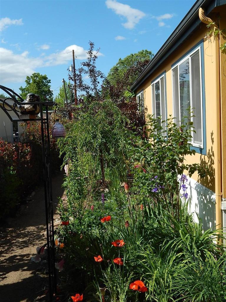 Secret Garden. This lovely 1782 sq/ft home, surrounded by lush plantings and a park like setting at the rear, is in the new section of Bear Creek Mobile Home Park. It combines the 3 bedrooms, 2 baths, living room, family room, dining area and kitchen in an open floor plan with a great flow. It is designed for generous space and flexibility for your furnishings. The master bath has a separate shower, a soaking tub and a unique sink and vanity. Lounge in privacy on the back covered porch. Space rent is $360 which includes water, sewer, trash. Close to shopping and restaurants. Great home, Great location.