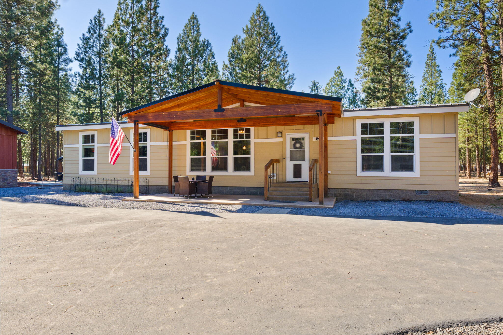 Welcome to your serene sanctuary. Nestled on a quiet 1.2 acre parcel in the Ponderosa Pines community, this custom home artfully blends forest living with thoughtful design. Spanning 1,680 sf & constructed in 2020, the open floor plan seamlessly connects the living, dining & kitchen spaces, ideal for both everyday comfort & entertaining. This single level home has versatile spaces, perfect for a home office or a guest room and a bright & inviting atmosphere with abundant natural light. The primary suite features vaulted ceilings & dreamy spa-like bath. Abundant storage, including large, walk-in pantry. Outside, an oversized garage/shop await, along with a separate structure for RV storage w/hookups. Enjoy evenings on the oversized patio with pergola or in the private hot tub & enjoy the ease of rural living with paved roads, year-round maintenance, & a low-cost HOA. Embrace quiet mornings under whispering pines & recharge your spirit in this unique forest hideaway.