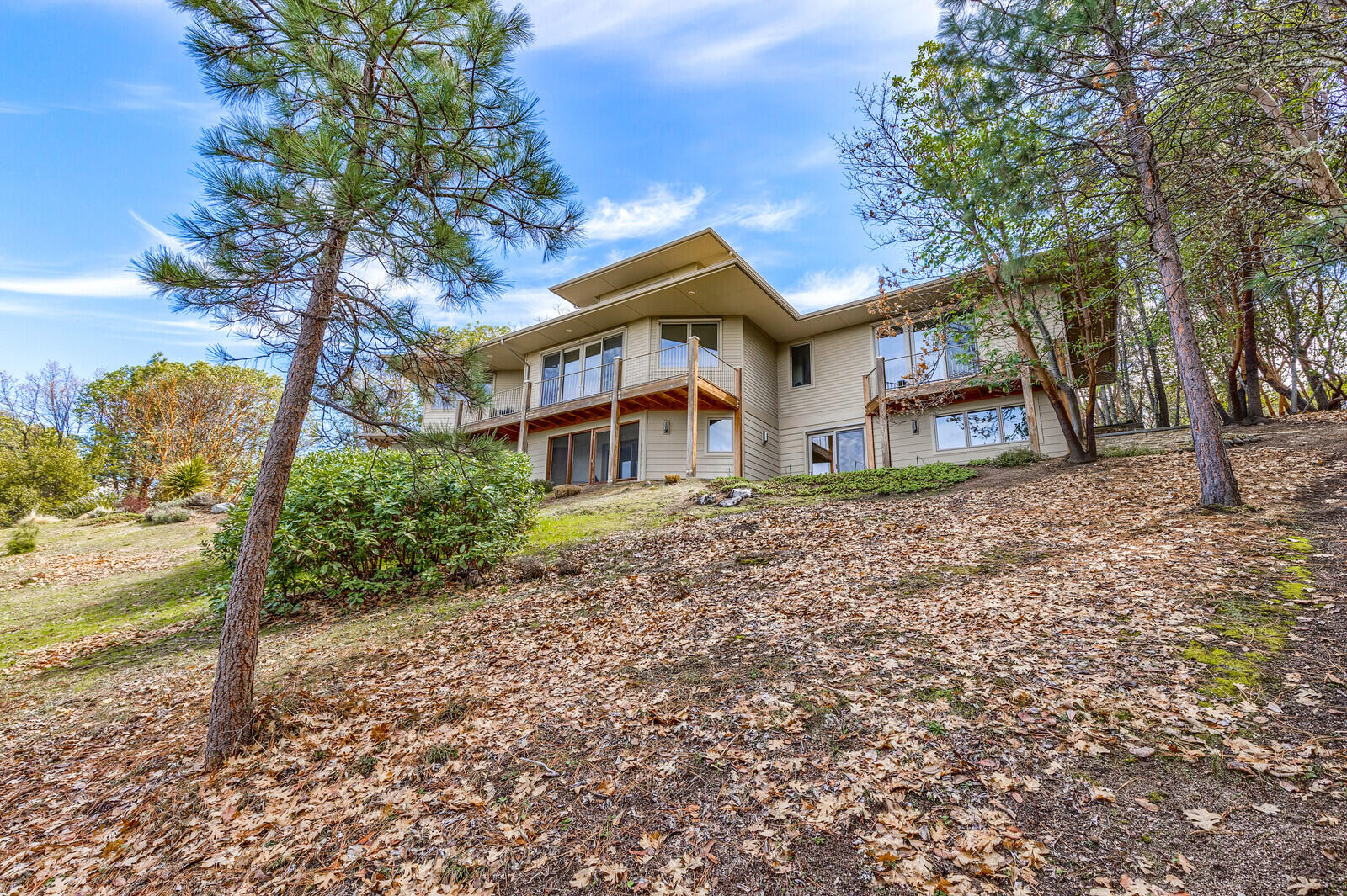 With extraordinary views throughout, this uniquely designed, peaceful and tranquil home is nestled on a private road only minutes from the plaza.   Ideal for entertaining, the spacious living room with a hidden media center flows into a formal dining room and an open kitchen featuring granite countertops, island and bar, window seating, and top of the line SS appliances with a French door to a lovely deck.  Windows and decks seamlessly draw the beauty outdoors into the main level primary bedroom and large walk-in closet.  Amazing views are featured yet again in the upstairs study with a large built-in desk.  Downstairs are two additional large bedrooms, family room, screened garden room and fountain.  Laundry room is on the main level with a mud room off the large, two car garage.  Energy efficient radiant heat is on all floors (under hardwood, tile, and carpet).  Natural landscaping is on automatic drip irrigation with walking trails immediately accessible.