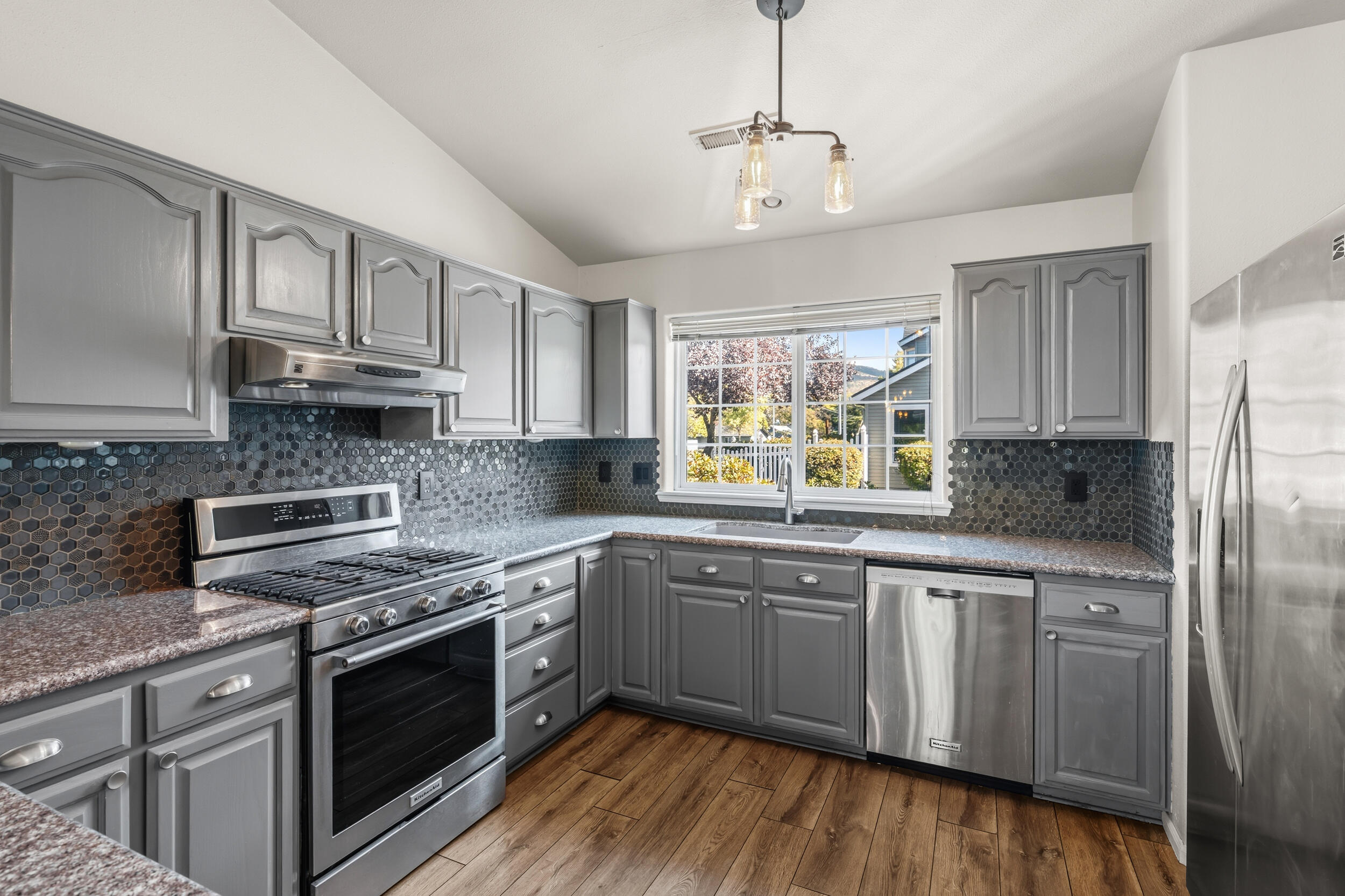 Move-in ready and freshly updated! This 3 bed, 2 bath townhome offers 1,435 sq ft of easy living in a fantastic  East Medford location. The main level features an open kitchen, dining, and living area with a cozy fireplace and brand-new flooring throughout. The downstairs primary suite includes an ensuite bath, while upstairs you'll find two more bedrooms and a shared bathroom. Enjoy peaceful views of the green space from your covered deck—no neighbors right behind you! The HOA keeps life simple, covering water, sewer, exterior maintenance, landscaping, clubhouse, and pool. Single-car garage for added convenience. Hassle-free living in a well-kept community close to shopping, restaurants, and everything the Rogue Valley has to offer!