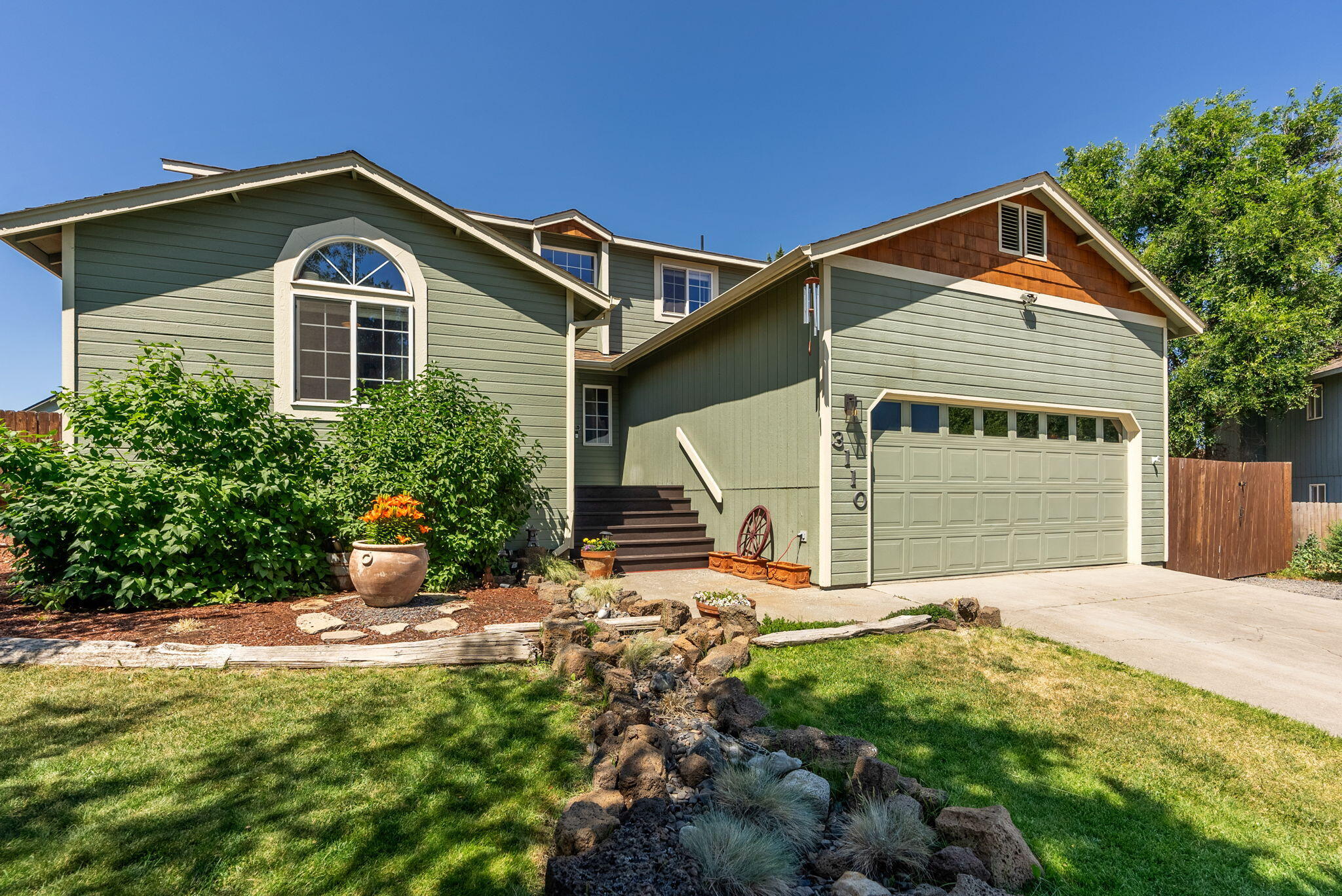 Desirable Providence neighborhood w/ .22-acre of land in NE Bend! This 1,792 sq ft home offers 3-beds including a primary suite on the main level with walk-in closet shelving, soaring vaulted ceiling, and updated bathroom w/ double vanity. Upstairs features a flexible bonus room or use as a 4th bedroom with shelving included. Enjoy updated laminate flooring downstairs, updated carpet upstairs, skylight in the upper bath with natural light, ceiling fans, slat blinds, cozy gas fireplace, digital coded entry, plus W/D included in the laundry/half bath. The kitchen has stainless steel appliances, butcherblock counters, updated sink/faucet, and updated lighting. Forced-air gas heating (2020), AC (2021), Nest thermostat, and Ring doorbell. Oversized backyard offers a partial covered back deck, raised garden beds, full fencing, landscaping, and gated RV/boat parking. The two-car garage includes extra storage and keypad entry. Close to schools, parks, and shopping — move-in ready!