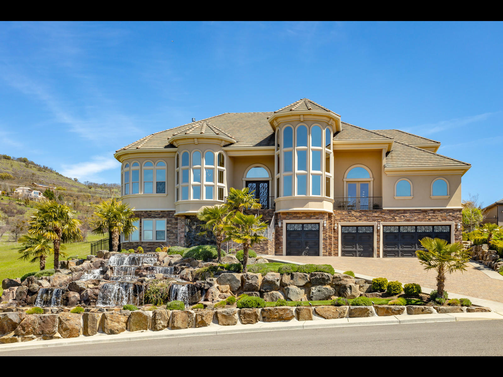This stunning masterpiece of architectural design is dramatic both inside & out. Be dazzled w/the cascading water feature & panoramic views of the valley & mountains. Through the front door, a grand foyer w/ 20 ft ceilings, elegant staircase, formal dining rm w/ built-in cabinet/bar & library parlor w/ floor to ceiling windows. Great room reveals an open concept w/designer gourmet kitchen, large pantry, heated tile floors, massive island & high-end appliances. Relax or dine in the sun parlor while overlooking the outdoor gardens. The outdoor space is an entertainers dream w/a custom gazebo, fireplace, waterfall feature & salt water pool. Elegant main level master suite boasts amazing views, fireplace, spa like bath retreat w/custom design luxury closet. Each of the homes guest suites feature private baths. Lower level retreat offers privacy & comfort w/entertainment rm, wet-bar, theater room & storage. 4 car garage, elevator access to all levels & park-like setting all on .53 acres.