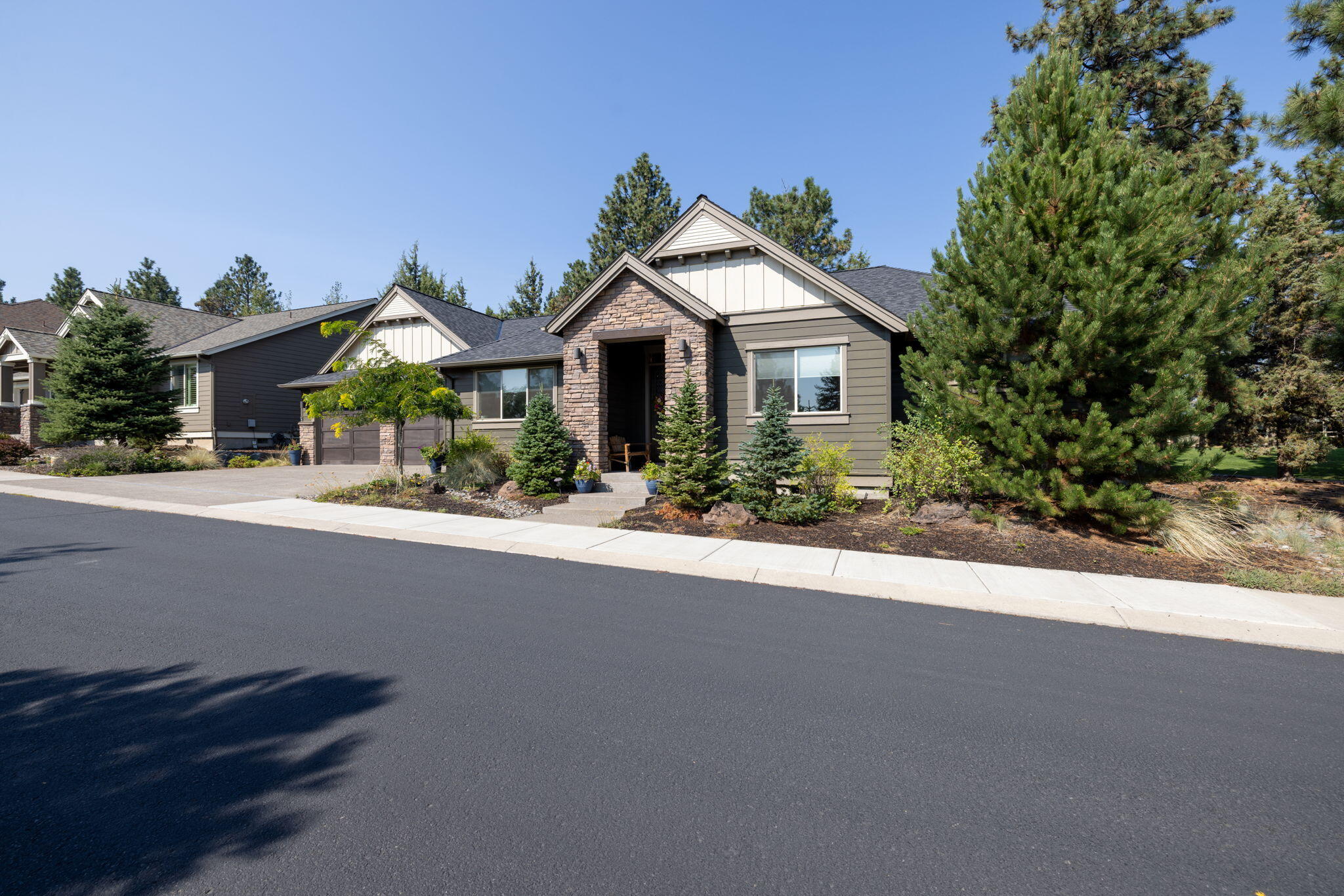 Experience refined single-level living just moments from the fairways in this beautifully appointed Pahlisch-built home, located in one of Northwest Bend's most desirable communities. Timeless craftsmanship meets modern design throughout this light-filled residence.  A welcoming brick archway opens to a spacious great room w/ soaring ceilings, custom built-ins, & an stacked-stone fireplace—perfect for everyday living & entertaining. The gourmet kitchen is thoughtfully designed w/ a 6-burner range, & a walk-in pantry. The private primary suite offers a true retreat, featuring a coffered ceiling, soaking tub, tiled walk-in shower, & large walk-in closet. Guest bedrooms & a full bath are thoughtfully separated in their own wing.  Additional highlights include engineered hardwood floors, & a 3-car tandem garage. Enjoy outdoor living from the covered patio overlooking HOA common space, offering added privacy. Vacant & move-in ready—this home is priced to sell & ready for immediate enjoym
