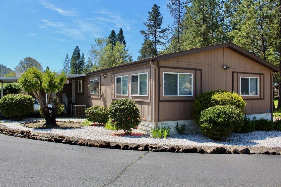 Well cared for home located on a nice corner lot. This 1992 manufactured home features recent updates such as plumbing, electrical, and newer appliances. The open floorplan offers laminate & carpet floors, and vaulted  ceilings. Enjoy the low maintenance landscaping and a covered private back porch overlooking a larger parcel) while enjoying the sunsets and viewing the local wildlife. The front offers covered parking for 2 cars and a small, locked storage shed. Conveniently located within Shady Cove and a short drive or walk to the Rogue River.