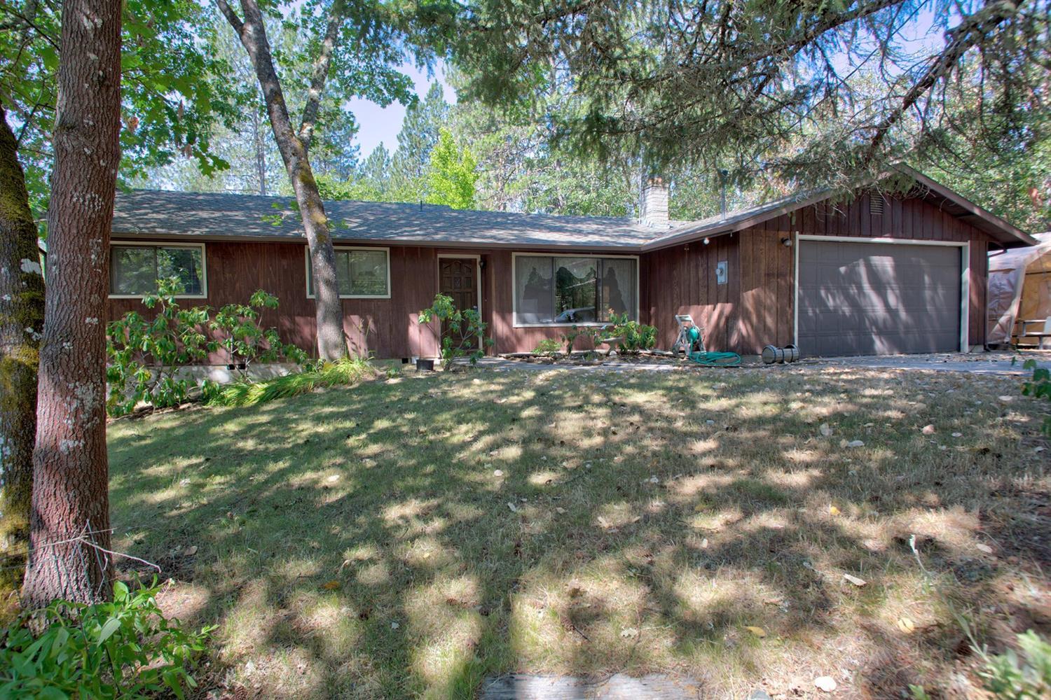 A gated entry leads you up through Madrone/Oak trees and rolling pastures to a nice 3 bedroom/2 bath ranch that just needs your personal touches and updates for you to call it your own. This home boasts vaulted wood ceilings, living room with brick fireplace, family room with woodstove, master bedroom and dining room that open out onto a new 700' deck spanning the entire back of the house, detached 2 car garage/shop and covered parking for a boat or small RV. Both garages have 220 amp for all of your projects. A nice little barn for horse/goats or whatever 4-H project you can think of and a garden with fruit trees complete this great little package. Property is fenced and gated, and only a quick 8 minute drive from downtown Grants Pass. Seller has installed a new 2000 gallon holding tank, updated plumbing, HVAC system and insulation in crawlspace. Take a look at this today before it's gone!