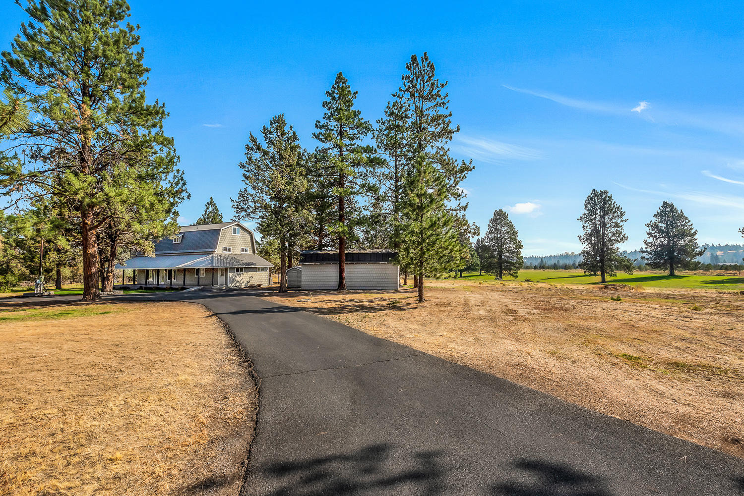 Love a Modern Farmhouse? How about a Classic farmhouse? This one-of-a-kind property offers a nearly 2100 square foot two story home, plus a gorgeous 2,240 square foot, three story, curved roof shop with 11'9'' by 11' 6'' door.  Situated on 25 acres of pure privacy just off of coveted Tyler road in Tumalo, it's only minutes to Downtown Bend, yet it is a true sanctuary. The three-bedroom three-bath home with wrap around porch and spiral staircase was recently updated with new windows, new carpet and fresh paint inside and out. The shop looks like a backdrop from a Ralph Lauren photo shoot with custom wood trusses, vintage flare and tons of opportunity to create the perfect shop, bunk house or spectacular home office. Nestled far from the road and boasting 10 acres of Tumalo Irrigation, this oasis could be anything you dream...a hobby farm, secret sanctuary or wildlife refuge. There is just so much opportunity in this dreamy, quiet corner of Tumalo.