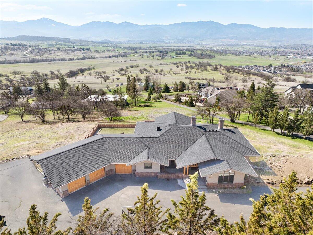 Exquisite 1-of-a-Kind Custom Built Home Located in the East Medford Hills on Aerial Heights, an Amazing Location, with Breathtaking Panoramic Views. Large private lot. Huge main floor primary suite, large gourmet style kitchen, excellent floor plan, large bedrooms, oversized 3-car garage, & RV parking with extra parking! Amazing front door opens to large living room with large view windows. With immaculate craftsmanship, the home showcases a beautiful hickory flooring, clear vertical grain fir cabinets, granite countertops, high-end plumbing & lighting fixtures, upgraded stainless steel appliances, custom cabinets, tile flooring, huge view decks, geothermal forced heat/air, generator, built-in sound system, 4 fireplaces, central vacuum system & more. Luxurious primary suite w/coffered ceilings, recessed lighting, Ultra air-jet tub, large tile shower, heated floors, & walk-in closet. This home is one of a kind! See ''Additional Information'' in attached Docs.