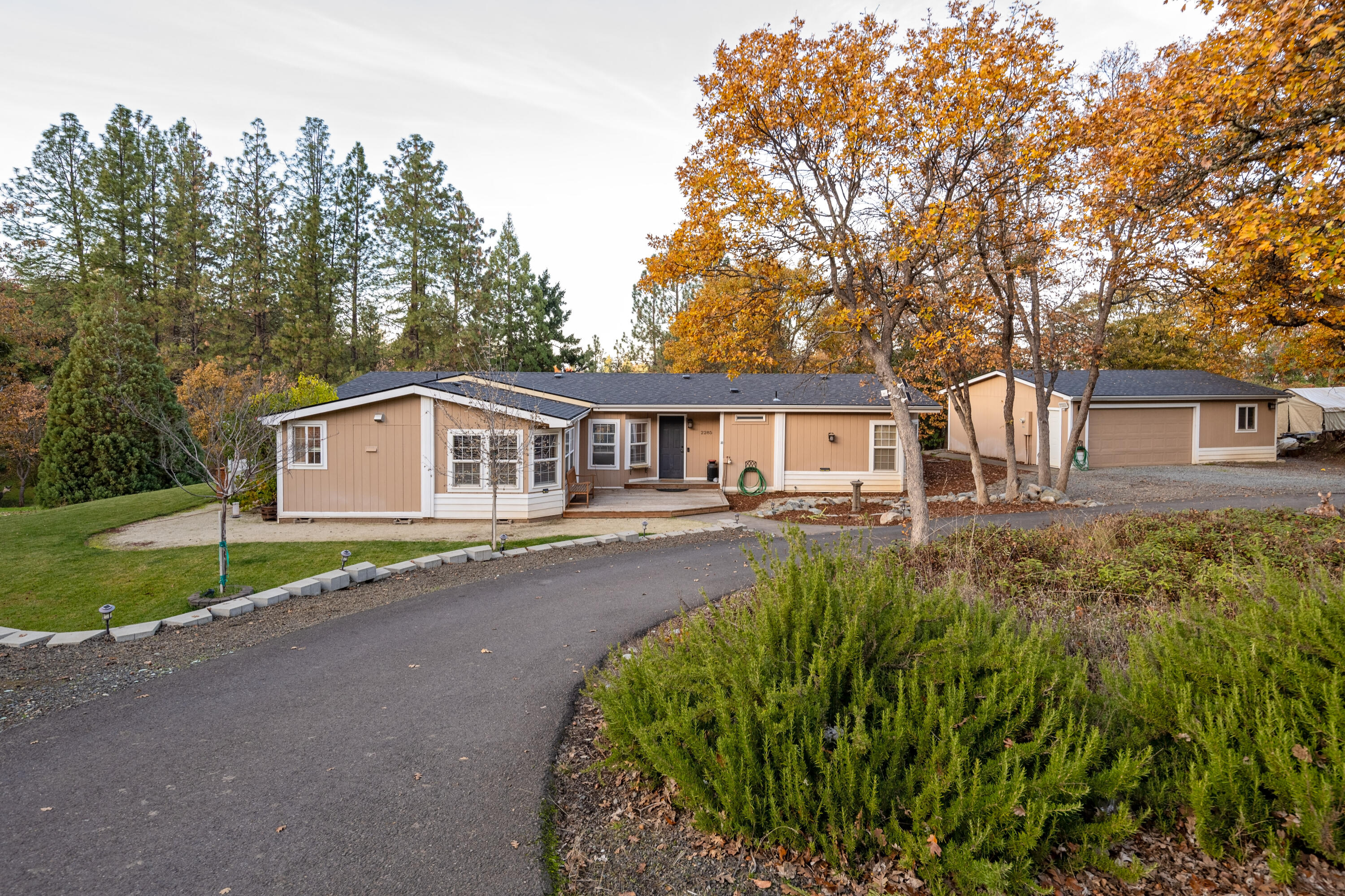 Discover peaceful country living on 3.5 acres with stunning hillside views, a creek that runs through the property, and beautiful areas to walk. This spacious 4-bedroom, 2-bath triple-wide manufactured home offers 1,942 sq. ft. of comfortable living with a split floor plan. The kitchen was fully remodeled in 2020, featuring stainless steel appliances, gas stove, and granite countertops. The inviting living room is perfect for relaxation and opens to a beautiful deck overlooking the backyard. The primary suite includes a large walk-in closet and a tiled walk-in shower. An oversized detached 2-car garage includes a generous insulated workshop of approximately 672 sq. ft.—ideal for hobbies, storage, or projects. Don't miss the new roof that was installed in 2023 and ample space for RV parking.