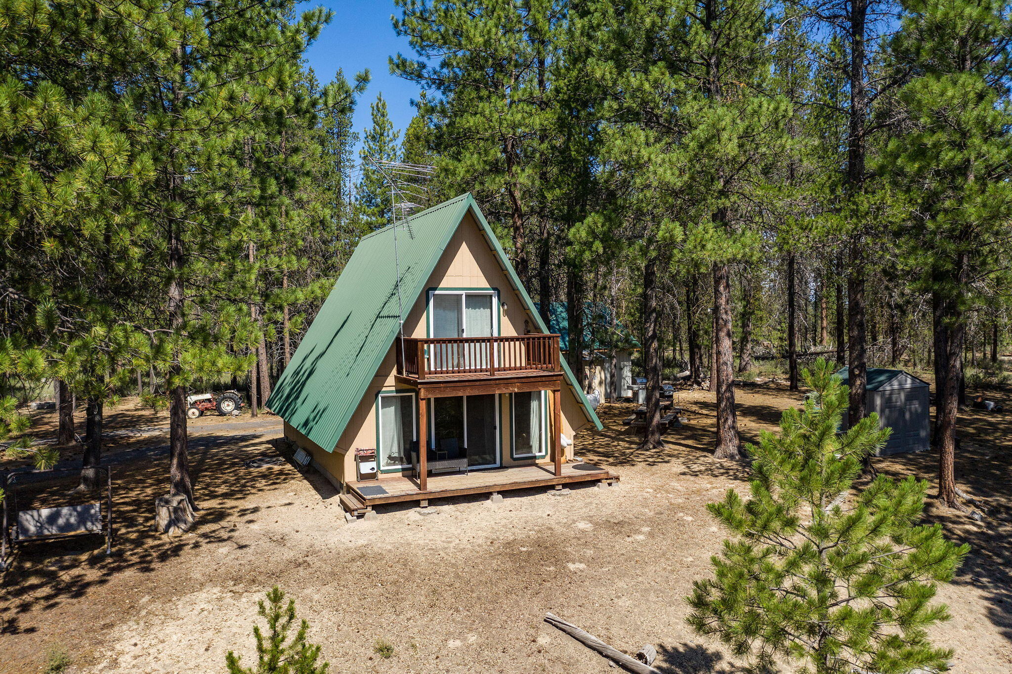 The ultimate 20 acre parcel of privacy at this off-grid cabin in the woods on the Little Deschutes! The river meanders through the property for fishing, floating, & fun. Located close to all of the High Lakes & Mount Bachelor.  2 bed, 1.5 bath cabin is nestled atop the hill for immaculate forest, wildlife, & mtn views. Blue pine interior & open living spaces w/views right out the floor to ceiling windows & sliding glass doors over the back deck. Primary bedroom ftrs sliding doors to an upper deck for relaxing mornings/evenings. A private bathroom upstairs is already plumbed for an additional full bath in addtn to the lower level full bath. Powered by 2 generators, on-site well, & surrounded by other large parcels of land. Traditional power available for future owners if desired. Detached 20x24 2 car garage w/one roll up door & man door plus shed. Picnic tables, firepit, & tons of space for RV parking, camping, entertaining friends/family! Do not use GPS to access, call for details!