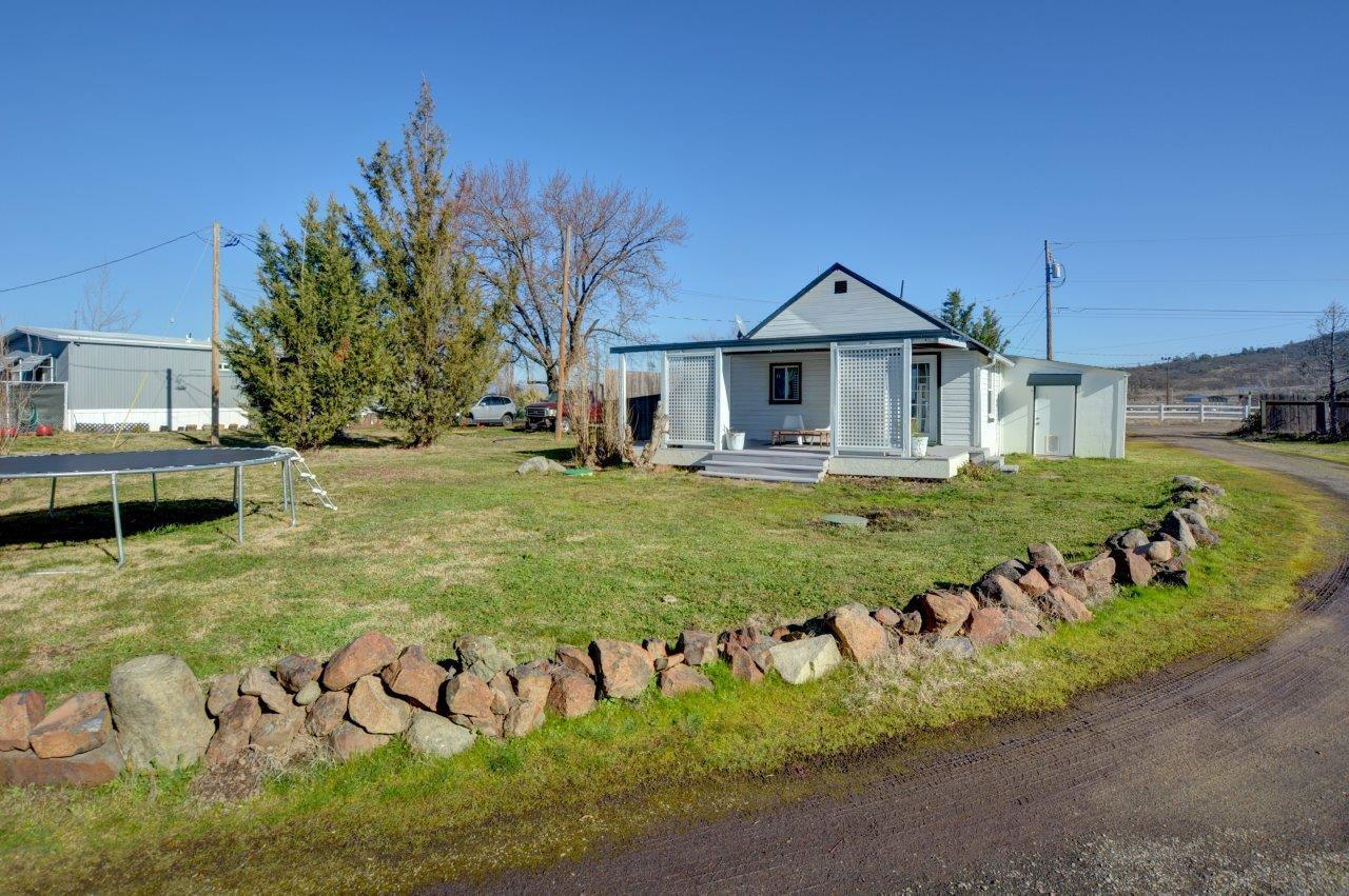 This property features two homes with the opportunity for multiple rental income streams or a family compound on 2.52 flat irrigated acres! The first home is a 1940s 1 bed/1 bath, currently rented for $1,000 per month. The second home is a spacious 1974 double-wide manufactured home with 3 bedrooms and 2 bathrooms, renting for $1,500 per month. The property also includes an RV pad with full hookups and laundry, perfect for an additional rental option. There's a detached 3-car garage with bathroom and a separate detached carport, along with several shed-sized outbuildings.  There are two septics, and three separate electric meters—one for the house, one for the manufactured home, and one for the RV pad. Multiple driveways and a circle drive make access a breeze.  Don't miss out on this rare setup that adds a ton of flexibility for today's living.  Call today!