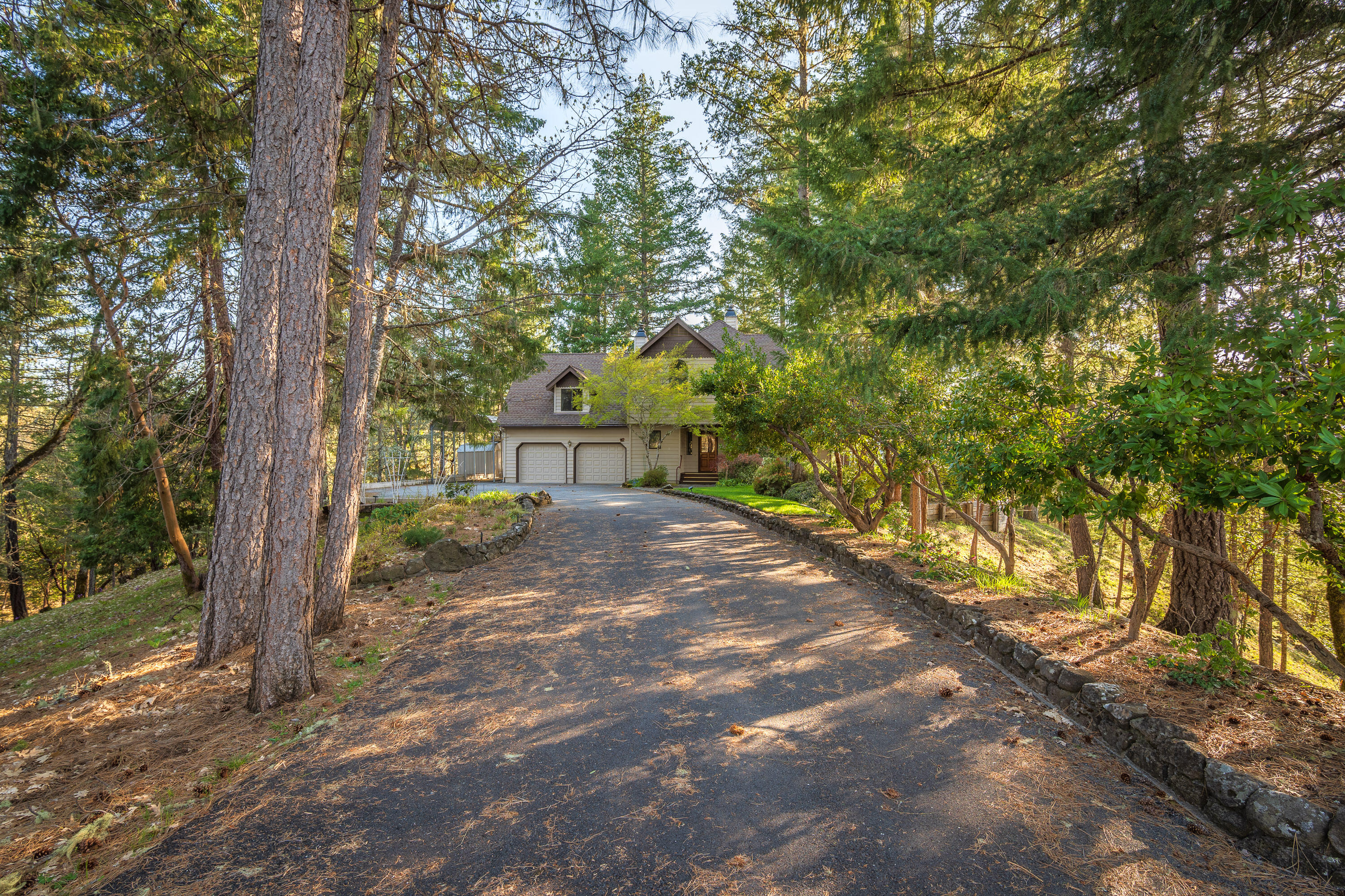 Are you looking for peace, quiet & seclusion with breathtaking views! Tucked up a gated & paved driveway you will find this beautifully maintained 2,470sf, 3 bedroom, 2.5 bath home built in a forested 5 acre setting with magnificent mountain & valley views! Remodeled kitchen with hardwood floors, granite counters, wall oven, cooktop, Bosch dishwasher, pantry & dining area! Spacious living room with a wood burning fireplace & astounding views. 400 sf bonus/game room with pellet stove over the garage. Wrap around covered redwood porch and Gorgeous decks let you entertain in the woods! The huge primary bedroom with it's Queen Anne's turret has a bird's eye view of the distant Rogue River & Robertsons Bridge! The tiled master shower is exquisite! Attached oversize 2-car garage plus covered 35-foot RV parking! It's like living at a vacation resort! Completely fenced property, with security gate & whole house back-up generator! Laundry room with mud sink, and a laundry chute.