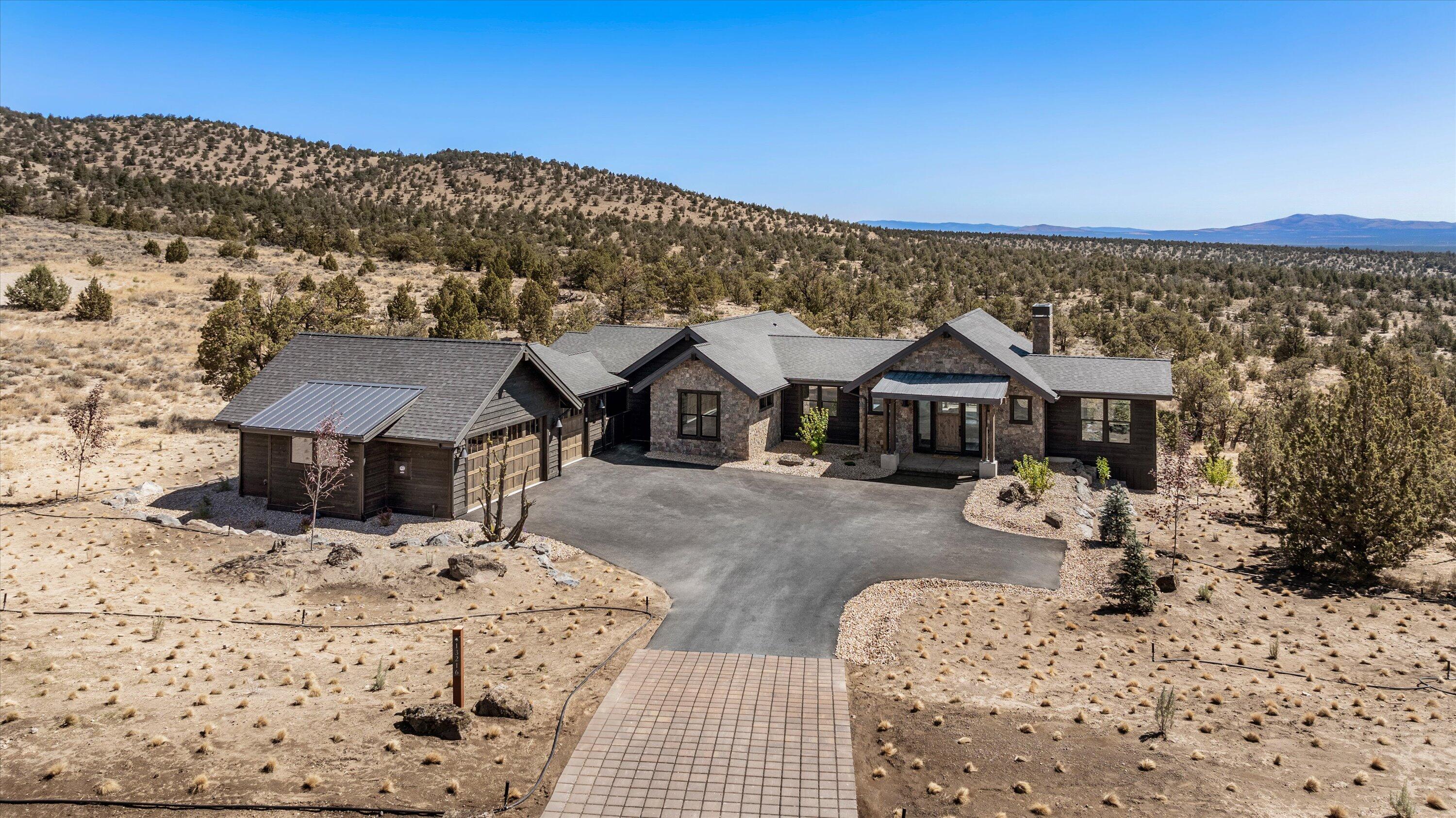 Quaint NW Style New Construction home with wildly expansive views to the south and east off of the spacious back deck. This home offers an open floor plan with hardwood floors throughout the main living area, a Great Room with a vaulted ceiling that features a solid, two sided, stone fireplace, a bright kitchen with large island for entertaining, and a perfect dining room for special occasions.  The primary suite has stunning 100 plus mile views to the southeast, while hemmed in by the natural terrain from the private deck, a large walk-in closet, double vanity, a soaking tub, and a floor-to-ceiling tile shower. Additionally upstairs you will find,  an office, half bath, and laundry room. Downstairs you will find a spacious bonus room, two additional bedrooms with a full bathroom, a back patio, and a generous three bay garage complete the home.