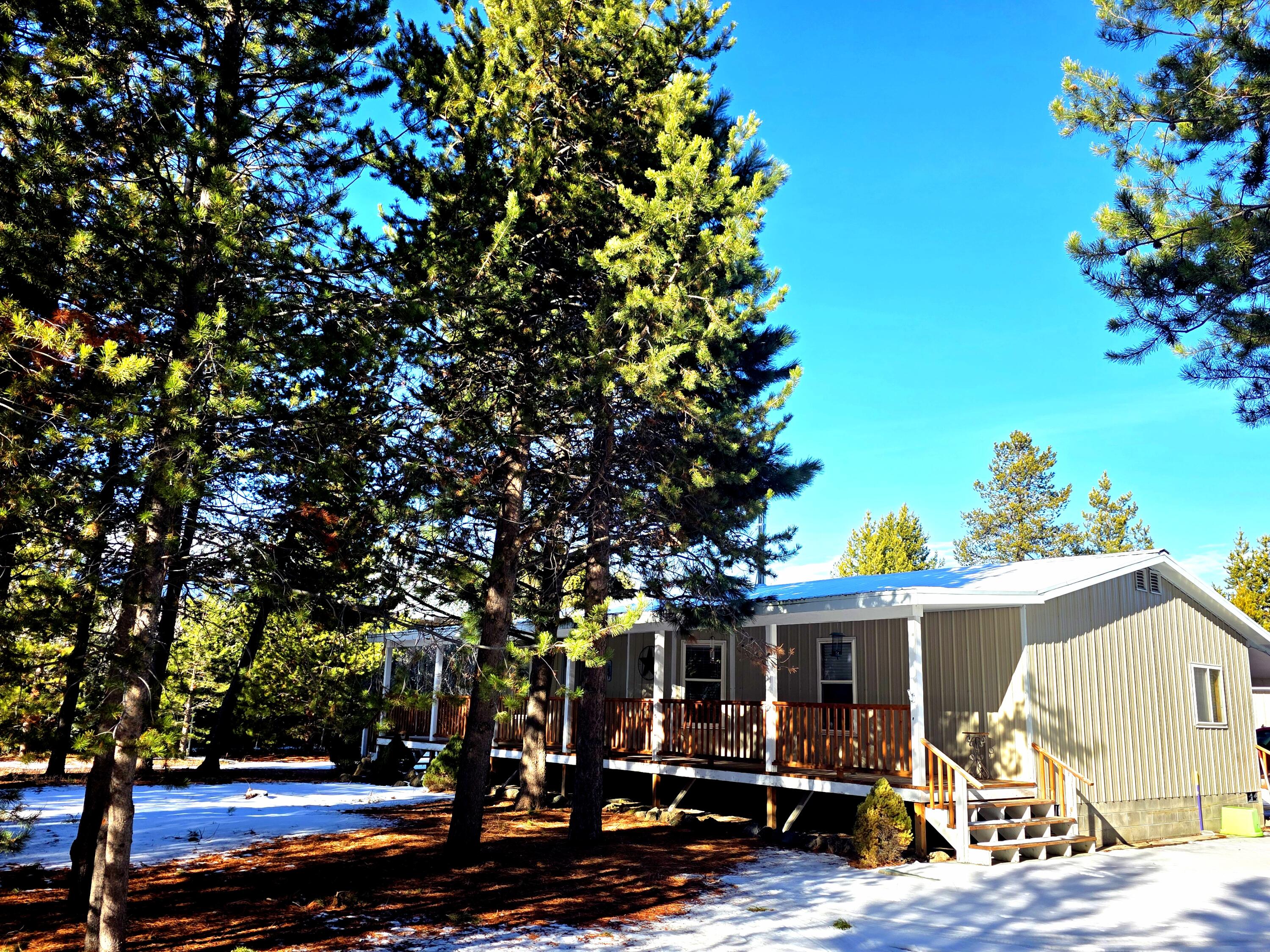 Nicely updated home backing up to public land located at the end of the road for exceptional privacy and a peaceful, quiet setting.
A newer wood stove keeps this 3 bedroom, 2 bath home warm and cozy throughout the seasons.  The kitchen has been updated with new cabinets, countertops and appliances, and features a pantry and canning too, just off the kitchen for added storage and functionality.
Enjoy covered front and back decks, a circular driveway, and just over 1 fully fenced acre.

The impressive 30x40 insulated shop is wired for 220 and includes a 16 foot covered wood or equipment storage area on the back side.  Additional features include 12x28 RV covered parking with electrical hookup, plus a shed and chicken coop both equipped with electricity.
A new 60 foot well adds peace of mind.  

Conveniently located just a 10 minute drive from town, this wooded, private, and well-cared-for property truly feels like a secluded oasis.