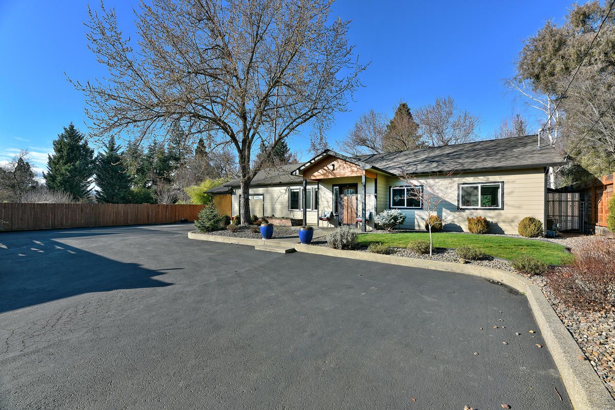 Rare Find! Custom single story home in Old East Medford on beautiful .43 acre lot completely redesigned and brought back to life in 2013.  Home offers a brilliant floor plan and loads of upgrades including raised ceilings with multiple skylights, an extensive lighting package, and a complementary assortment of tile, hardwood, and granite.  Kitchen is well appointed and features an upgraded appliance package, custom cabinets, pantry, and large island bar with prep sink in an open concept to the eating area and family room. There is a cozy wood stove in the family room too.  A large covered back patio overlooks the expansive and beautifully landscaped yard featuring two additional storage sheds, mature trees, and raised garden beds.  This home sits well back from E. Main offering ample asphalt parking, a large carport and a deep 360 sqft one car garage, plus a small private office area that looks out to the back yard. Truly a must see property.  Schedule your appointment soon.