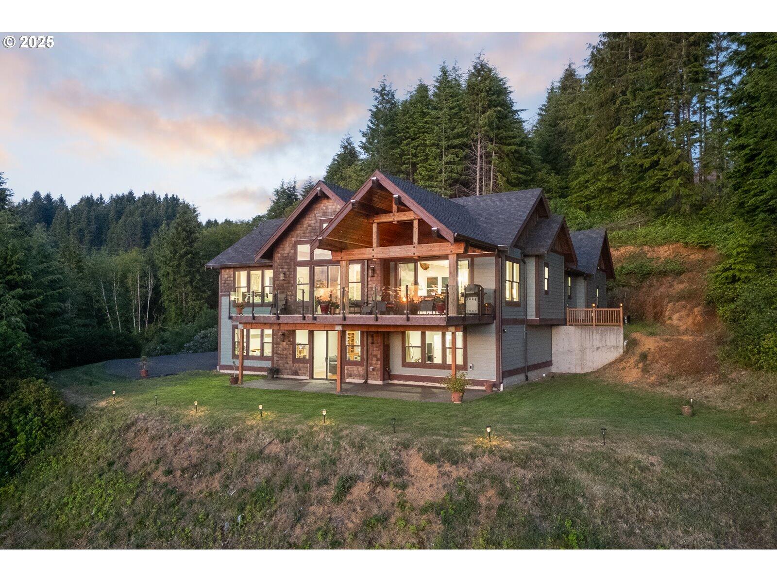 Custom Craftsman on 5 Acres Overlooking Devils Lake - Lincoln City, Oregon. Welcome to your dream home on the Oregon Coast! This custom-built craftsman offers over 3,500 sq ft of open living space on 5 acres with panoramic views of Devils Lake, just outside Lincoln City. Featuring two main-level en suites, vaulted ceilings, 9-foot ceilings, and walls of windows, this home is designed to capture lake views from nearly every room. The gourmet kitchen includes granite and quartz countertops, glass tile backsplash, built-in convection ovens, a butler's pantry, and hardwood floors, creating the perfect space for entertaining. Step out onto your 256 sq ft deck with gas hookups for a barbecue and fire pit, or relax on the covered front porch with 8-foot entry doors.