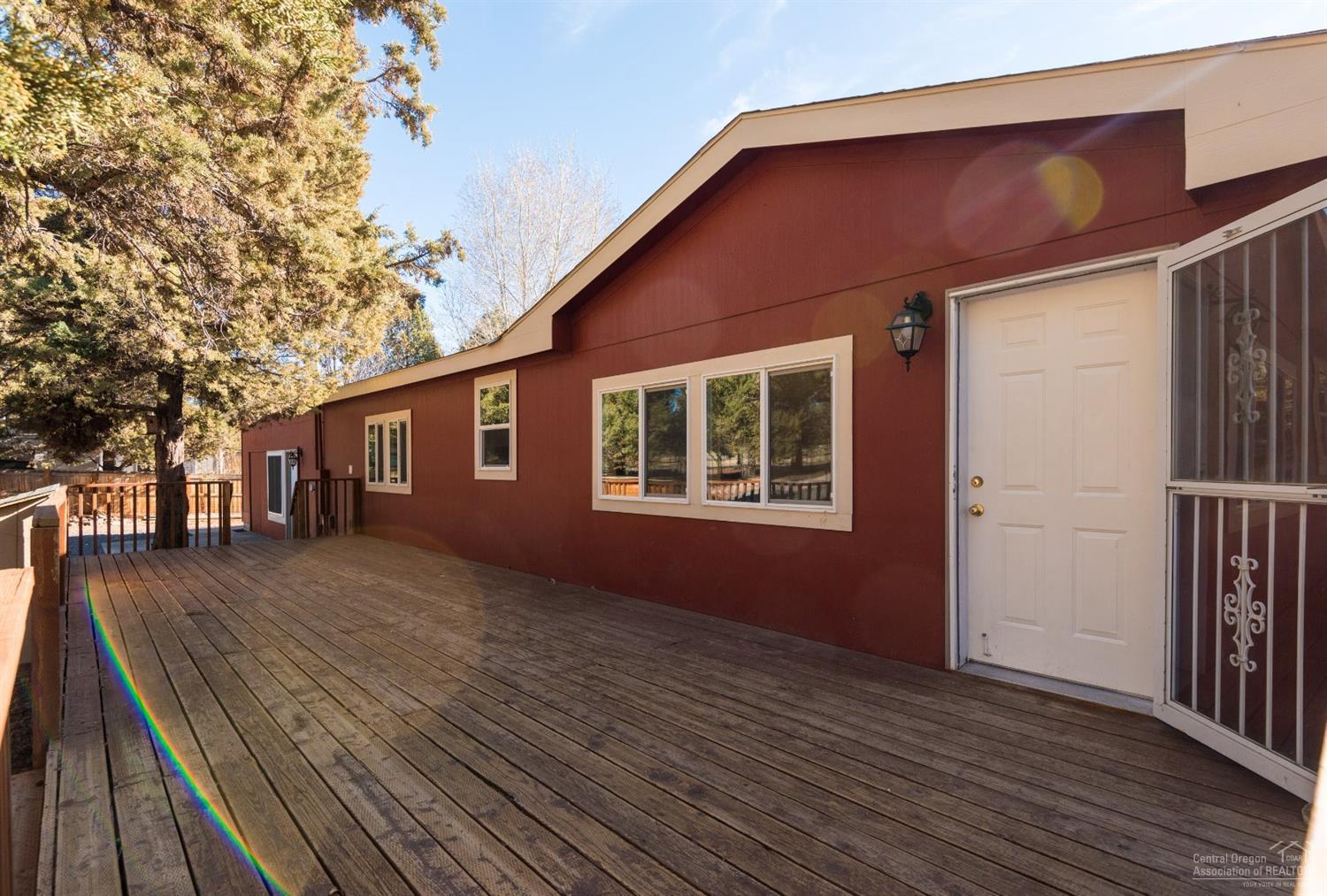 Nicer than new manufactured home on fully fenced acreage in Crooked River Ranch. This home features a great room design, spacious kitchen w/ breakfast bar & separate island, all stainless kitchen appliances included in the sale, a generous pantry & utility that comes equipped w/washer/dryer, master separation & large master suite, Central Heat/AC, wood burning fireplace, a screened back deck w/ pergola, attached solarium/greenhouse, an attached shop/activity room, planter boxes, & an in ground trampoline!