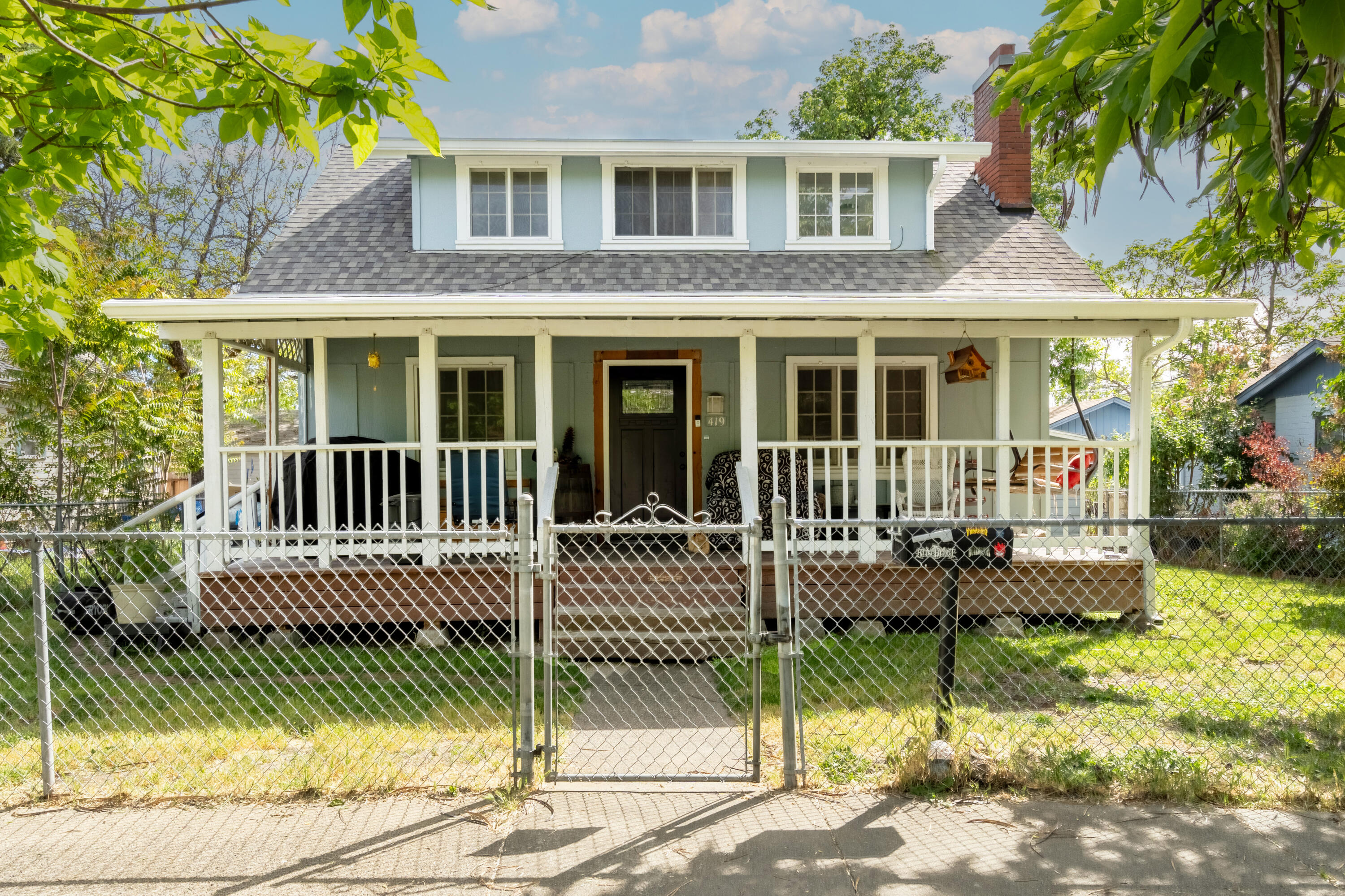 Step into a delightful piece of history with this charming home, perfectly capturing the essence of the early 1900s. You'll immediately feel at home on the inviting covered front porch. As you enter, the expansive living room welcomes you with a stunning stone fireplace, creating a warm and cozy atmosphere. The flow from the living room to the dining area and futher on ito the updated kitchen . The kitchen has plenty of cupboards and counter space to enhance your cooking abilities.

The primary bedroom, conveniently located on the lower floor with its own en suite bathroom, ensures comfort and privacy. Upstairs, you'll discover four additional bedrooms and a full bath, providing ample room for everyone to unwind. Outside, the fully fenced yard features a lovely patio, alley access, and a garage/shed, perfect for all your outdoor needs. This home is truly a wonderful place to create lasting memories!