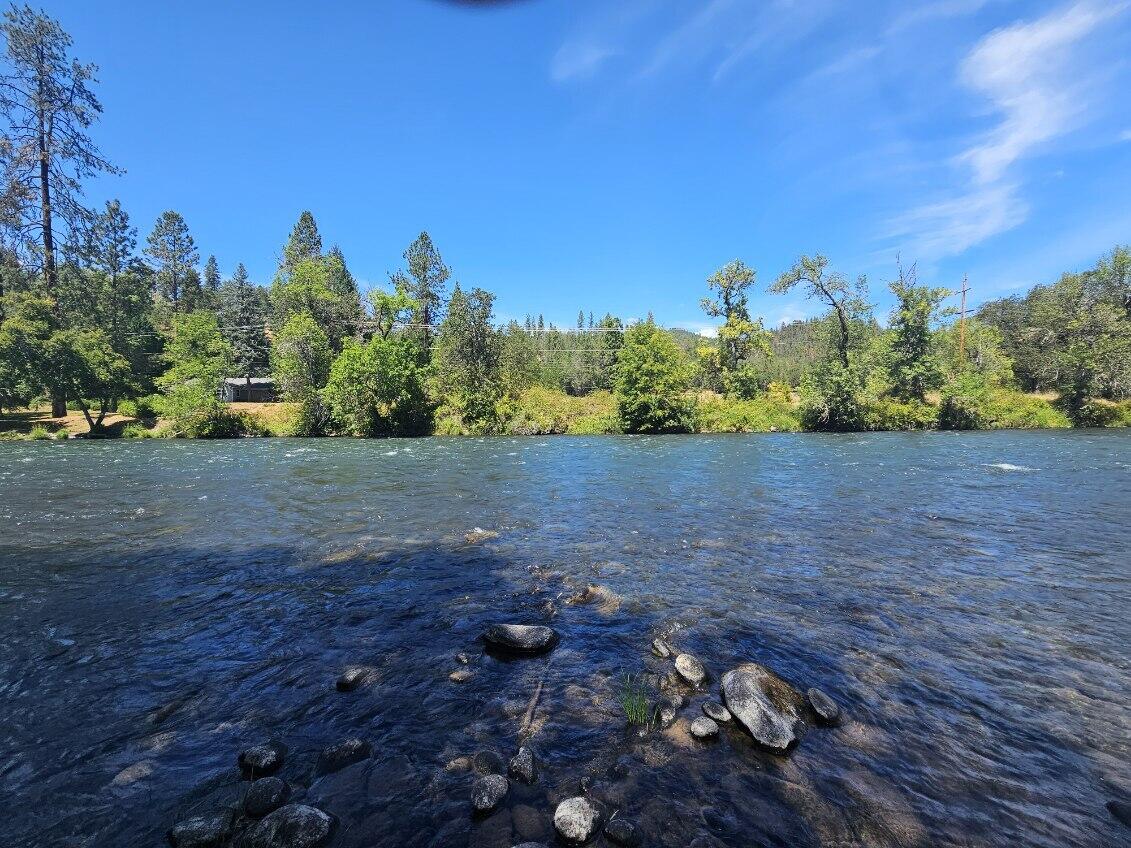 Private. Pristine. Unrepeatable. Over 21 acres with 1500' of Rogue River frontage—your own hidden wilderness sanctuary. Once a manicured showplace (see photos section for photos from previous listing), this rare estate now needs only cosmetic polish—flooring, paint, cabinet repairs, landscaping—to reclaim its glory. Structure & systems are solid and inspected. 2406 sq ft 2-story Craftsman w/mahogany wrap-around porch, soaring ceilings, main-level primary, river-view living room flooded with natural light, chef's kitchen w/custom cabinetry, and loft office/bonus area. Legal guest house, finished garage/shop, abundant water, underground power. Watch elk wander through the evergreens, fish for salmon & steelhead from your private shore, and never see a tourist. Value-priced at $950,000. Possible owner carry terms with qualified buyer.