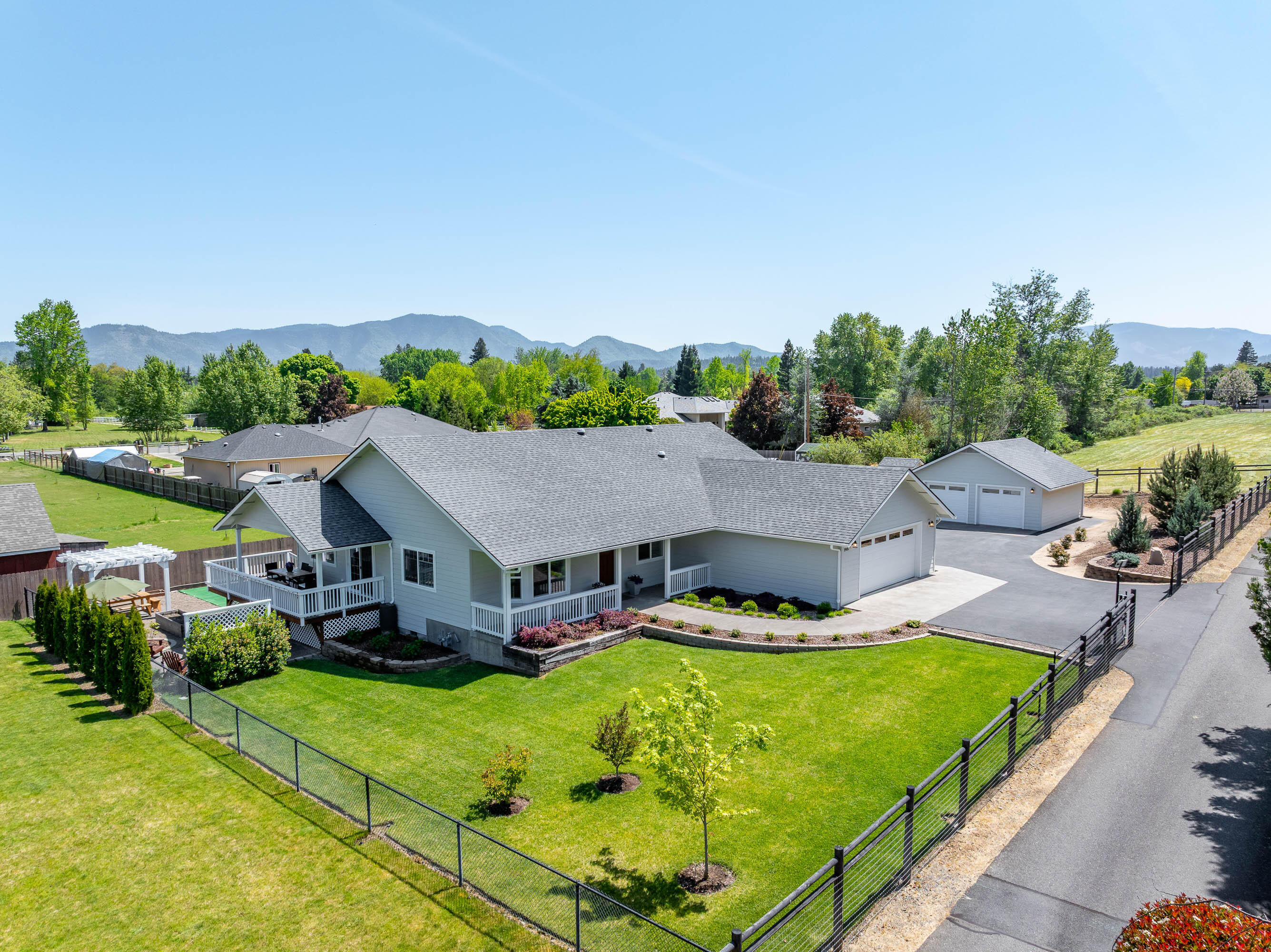 This meticulously maintained home with an office sits on a fully usable 2-acre lot in desirable School District 7. The open floor plan offers spacious living, & the primary suite includes direct access to a private hot tub—perfect for relaxing. Outdoor amenities are ideal for entertaining & enjoying Southern Oregon living, featuring a covered deck, fire pit, low-maintenance turf area, a pergola, & beautiful landscaping. Approx. 2/3 of an acre is fully fenced—perfect for pets—& landscaped with lush lawn and irrigation. The remaining acreage includes irrigated pasture with GPID (mostly fenced), along with fruit trees & raised garden beds, offering a perfect setup for hobby farming or gardening. A 24' x 24' detached shop/garage includes a convenient half bath, plus a 10' x 12' storage shed for extra storage. Located just minutes from the Rogue River & close to town. Buyers to perform their own due diligence with appropriate agencies regarding condition, permits, zoning & intended uses.