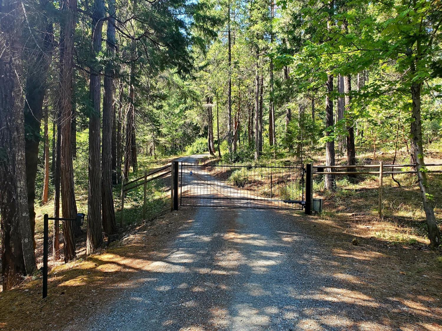 Backed on two sides to BLM land, this 28 acre multi faceted property is a must see. Two permitted homes exist on this site with a finished attached garage on the main house and another fully finished detached garage shop located fairly close to the second home. Extremely private and removed from any main roads, this land layout includes a year round creek through the woods, large lawns in both the front and back yard, a small vineyard and a wide assortment of fruit producing trees. A private gated entrance will guide you down to a fork in the front yard leading to either the convenient front yard parking or around to the main garage. The primary house is 2747Sq feet with three bedrooms and three full bathrooms. The second home is 1008sq feet with two bedrooms and one bathroom. Aside from just being a nice year round aesthetic, the creek on this property also powers a grid tied hydroelectric system to offset the electric bill.