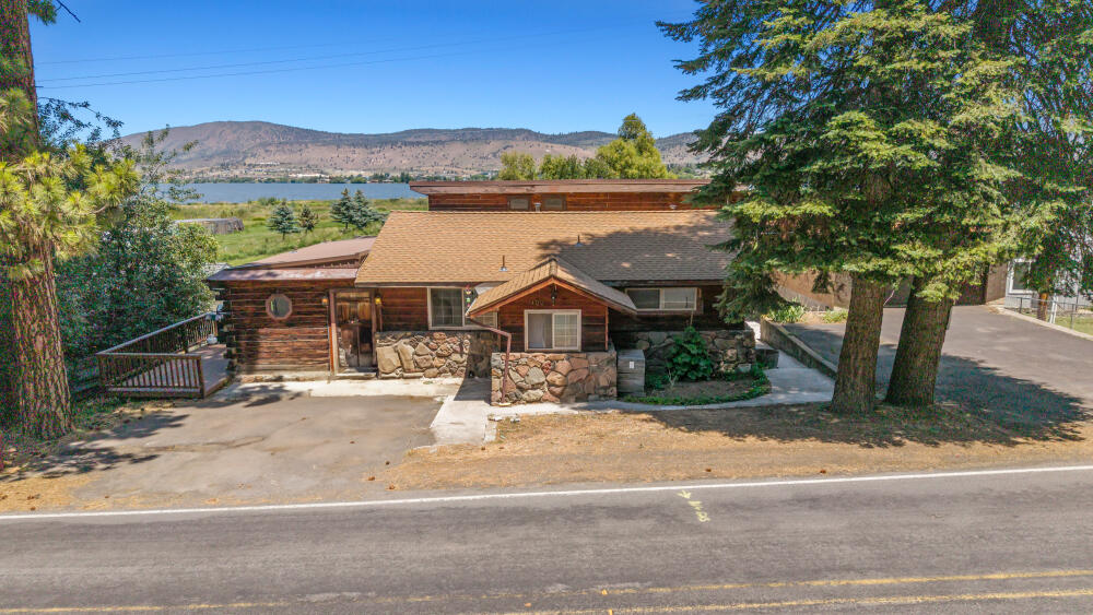 Incredible lake views with a 3 bay detached shop make this an incredible opportunity! This is a log style/built home, and it has been converted into a duplex, or one single family home with a 2 bedroom 1.5 bath attached ADU. Plenty of parking and storage with an additional single car garage, and some interior stalls for smaller horses or other farm animals below. Beautiful garden, fenced property, and tons of space! Enjoy the peaceful views of the lake, wildlife and the breeze from the covered deck and lower covered patio. With 2,880 square feet and just a little under an acre of land at .85 acres, this property has a lot to offer!