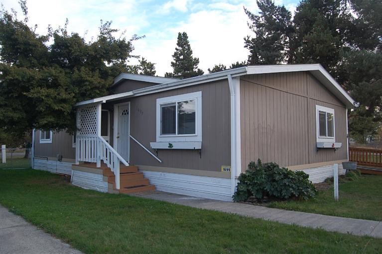 The home is located in manufactured home subdivision, not a 55+ park. Park is on water supplies by a community well and city sewer. Located closed to hospital, shopping, restaurants. Home features 3 bedrooms, 2 baths, and is ready to be moved into. All appliances included, including washer and dryer. Barn style storage building next to the carport. There is a ramp on the back of the home for easy access. The monthly park fee is $415.