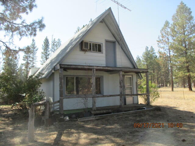 3.4 acres of level land and on paved road.  The property is fenced and has tall ponderosa trees.  The home is a 2 BR (A-frame) and needs lots of TLC.  The property is being sold as-is, included  are several vehicles, trailers, personal property and debris.  This can be a beautiful Ranchette after clean-up.  Note: The boat, two horse trailers and (1) tandem axle utility trailer are not included in the sale and are being removed..