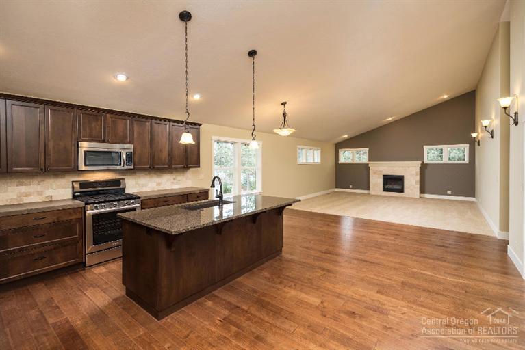 Living is kept simple in this large single level home. Huge vaulted ceilings make this already open floor plan feel even more spacious. Designer chosen finishes including granite island, porcelain counter tops, tile floors,tile shower, and birch hardwood flooring throughout entry and kitchen/dining area. Furnace and water heater are set in additional framed out garage space allowing for more room in garage. Located in desirable Hidden Hills neighborhood.