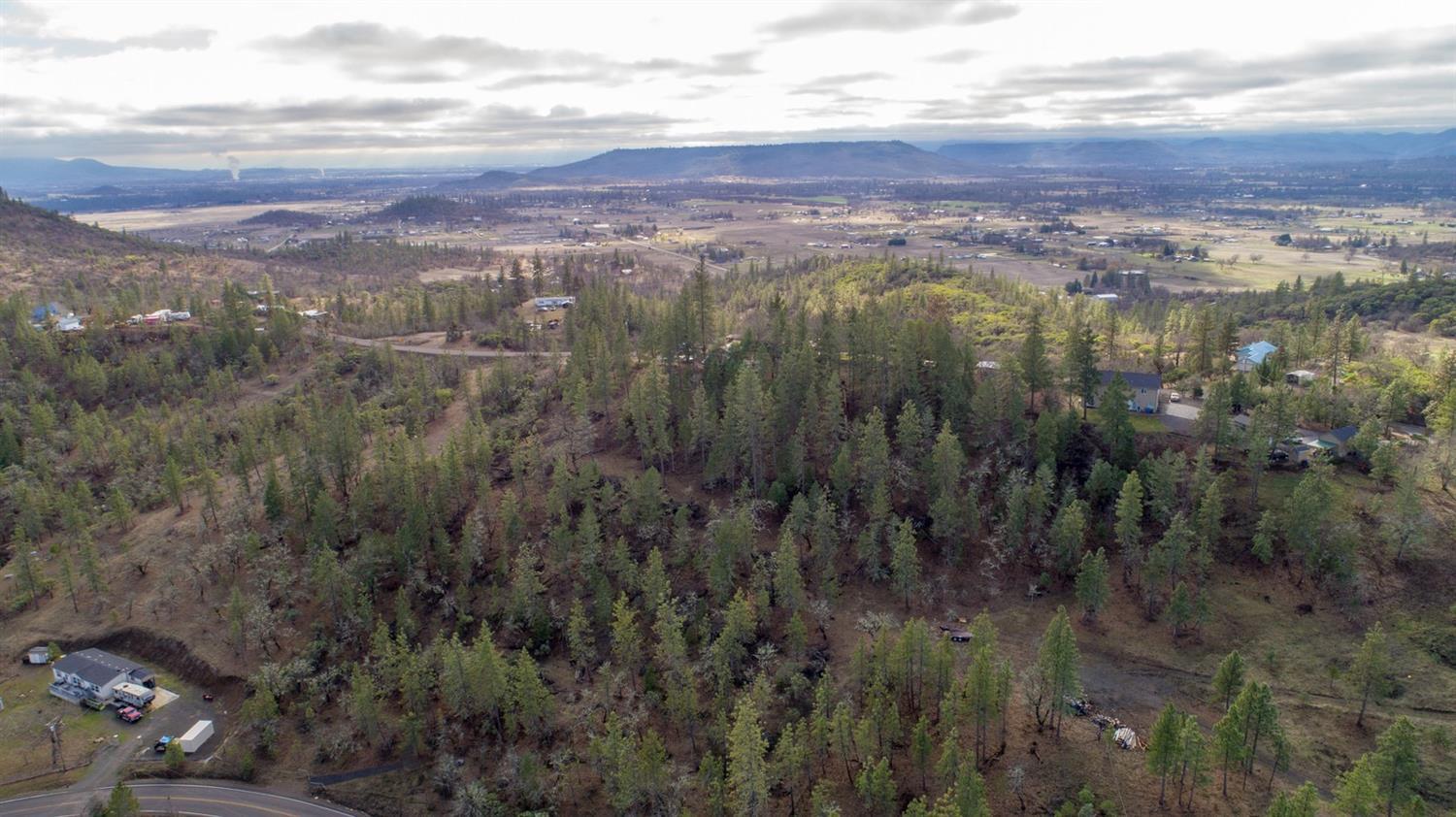 The 360 degree views from this 5 acre property are spectacular! Not often do you find a property with views that include the Rogue Valley, both the Upper and Lower Table Rock plus the night ski lights on Mt. Ashland. This 1860 sq. ft. 3 bedroom, 2 bath with a split bedroom floor-plan has been remodeled in a comfortable craftsman woodsy like manner. There are open beams and vaulted ceilings in the living room, gorgeous wood flooring thru out. Brand new carpets in the the bedrooms. Unique interior stone and rock work. Centrally located wood stove. Custom wood cabinets and neutral colored granite counter tops in both the kitchen and bath. The master suite is large, filled with windows and features double closets. The laundry room is spacious and filled with natural light. The entire front of the house has decking perfect for entertaining. Back deck with a low-set hot tub and great privacy. Bi-level shop and detached garage. Paved driveway off of the County Road. A 5 acre dream property!