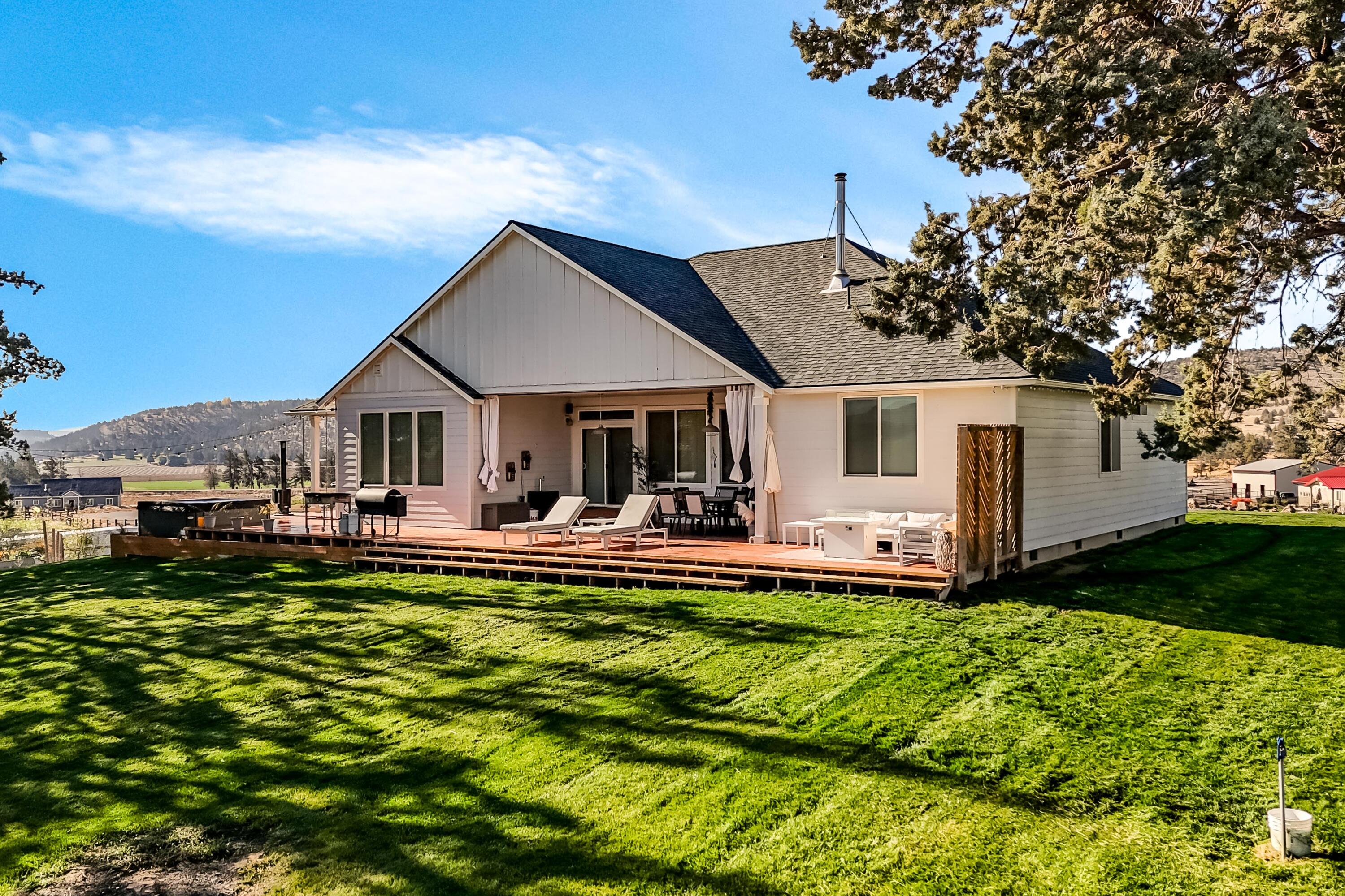 Welcome home to this stunning 2019-built single-level ranch, perfectly blending modern comfort with serene country living. Set on 5 peaceful acres—4 with irrigation rights—this property offers room to roam and breathe. Inside, you'll find an inviting great room with vaulted ceilings, abundant natural light, and an easy flow for everyday living or entertaining. The kitchen and living areas open to a massive back deck featuring a brand-new hot tub, ideal for soaking under the stars. Four spacious bedrooms plus a den provide plenty of room for work, guests, or hobbies. The property is fully fenced, with underground sprinklers and an owned solar system for energy efficiency. Enjoy privacy, comfort, and wide-open views—just minutes from the heart of Prineville.