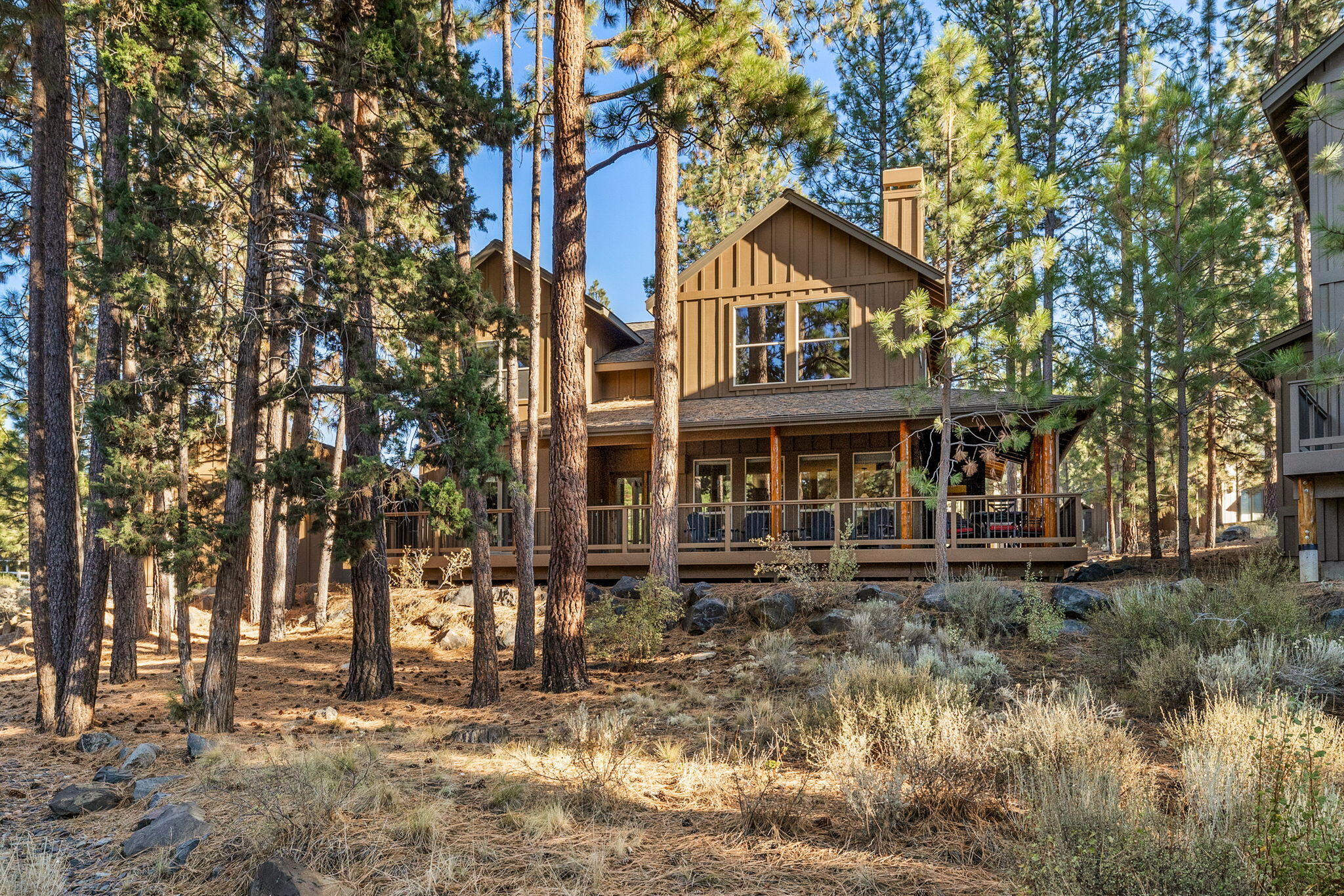 Nestled in River Wild at Mt. Bachelor Resort, this fully furnished lodge-style home is a rustic yet elegant retreat. The great room features a towering stone fireplace under cathedral ceilings, merging modern comfort with rustic charm. Two primary suites and a guest room offer luxury and versatility, ideal for full-time living, unforgettable holiday getaways, or investment as a rental property. Outside, a wrap-around porch invites BBQs, morning coffee, and mountain air. A detached garage stores outdoor gear and vehicles. A sparkling pool and spa are a short stroll away for relaxation & recreation. Whether you seek Mt. Bachelor's slopes, mountain biking on Phil's Trail, river walks, fishing on the Deschutes or enjoying Cascade Lakes, this location has it all. Short-term vacation rentals are allowed per the HOA & City of Bend, offering a lucrative opportunity to share this incredible home. Experience the ultimate mountain lifestyle in the beauty of River Wild. Your adventure begins here