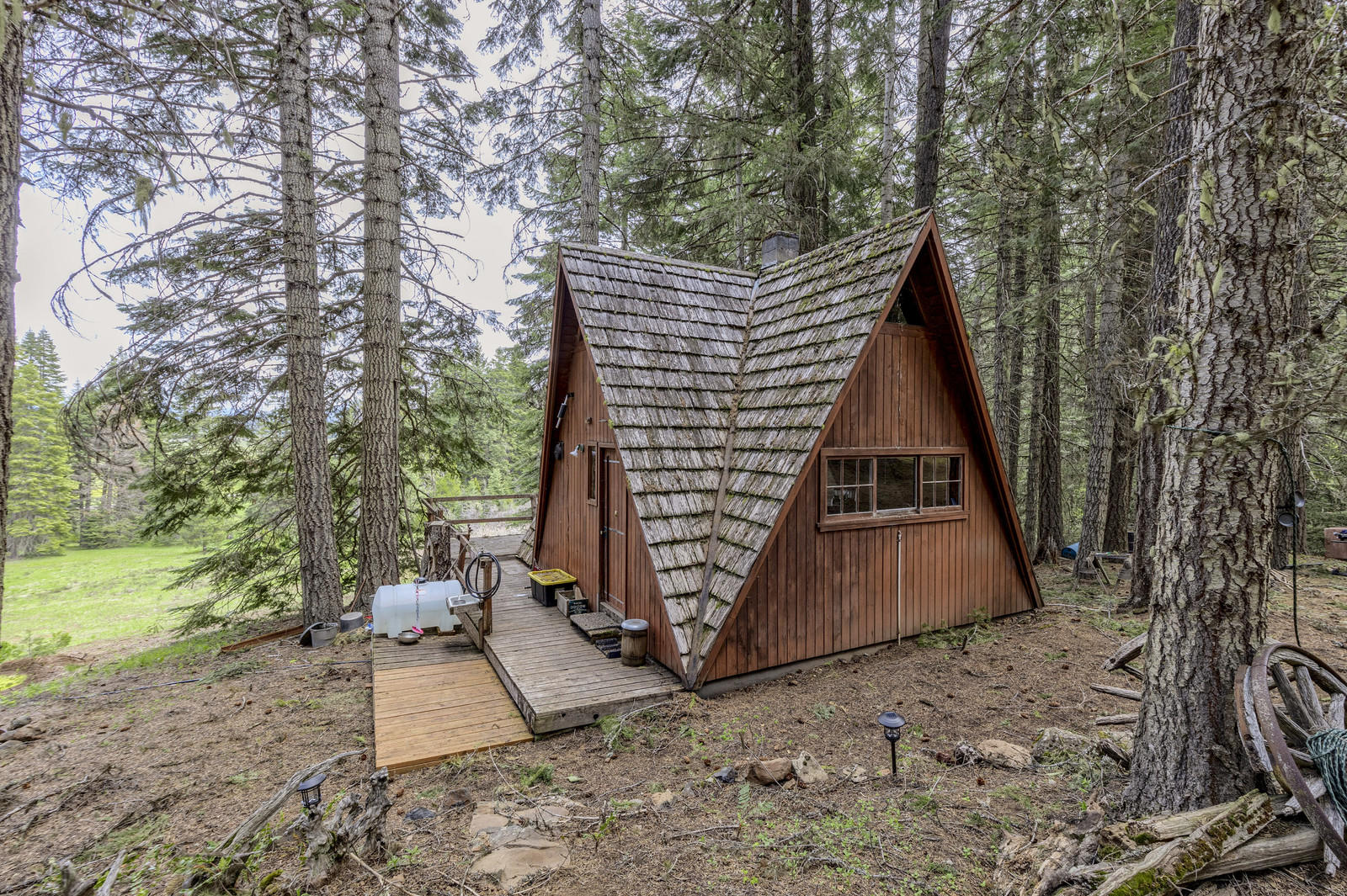 This 68+ acre parcel has the peace & quiet of a forested high mountain lake area but is only about a 1/2 hr drive from Ashland, Oregon. The location could not be better as it sits less than a mile from Howard Prairie Lake & is also close to Hyatt Lake & Lake of the Woods. The rustic but functional A-frame cabin is nestled in the woods, w/ a grassy meadow & seasonal pond below & peeks of Mt McLoughlin & Howard Prairie Lake. The cabin is a legally recognized structure, built prior to zoning laws & has a separate A-frame storage building. The property is fully off grid, has a pit toilet, & uses spring water gravity fed to the cabin & a generator for power. County maintains road year-round.
There is merchantable timber, including scattered old growth trees. The property has been used as a family retreat w/ RV parking areas & abuts BLM lands on 2 sides. Buyer shall rely on their own research re: property attributes & allowable uses of this property including Home-site suitability & timber.