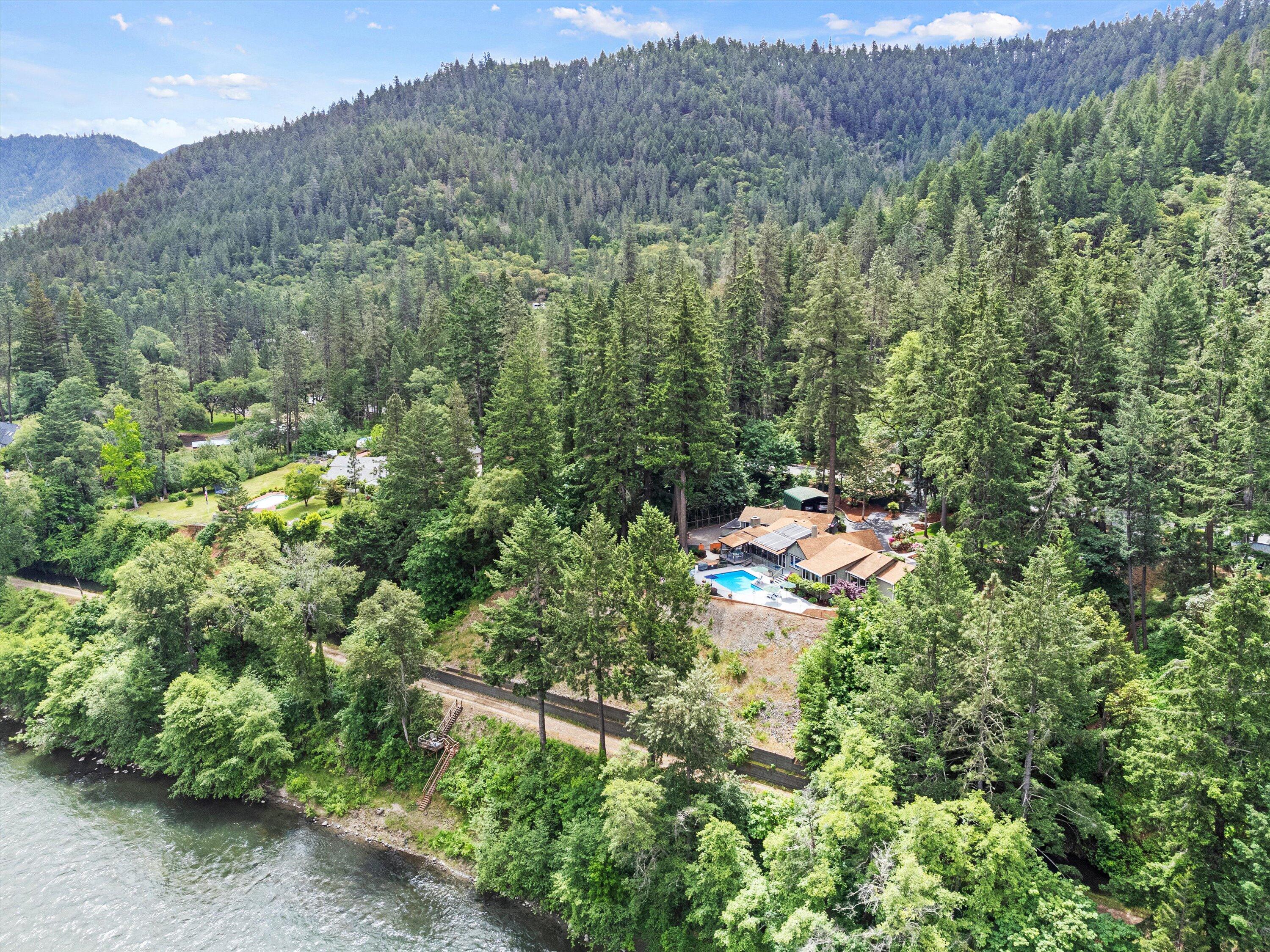 Rumored CLARK  GABLE'S River Retreat. Nestled along the serene banks of the Rogue River, this exceptional property offers a rare opportunity to own a luxurious waterfront retreat. Spanning 2.4 acres of beautifully landscaped grounds, this estate features a furnished 3,949sq ft main house and a charming 1,515 sq ft ADU perfect for multi-generational living, rental income or guest. Main house features, 3 BDR & 3 bath. A  a spa-like en-suite with views of the river. A gourmet kitchen with granite countertops equipped with high-end appliances. As you come into the living room  & den you have vaulted ceilings, hardwood floors, and expansive windows frame breathtaking river views. Two cozy fireplaces. As you walk out to two large decks that over looks the Rogue River with a amazing pool for all your entertaining or relaxing while you enjoy world class fishing on the river or a walk along the river bank.