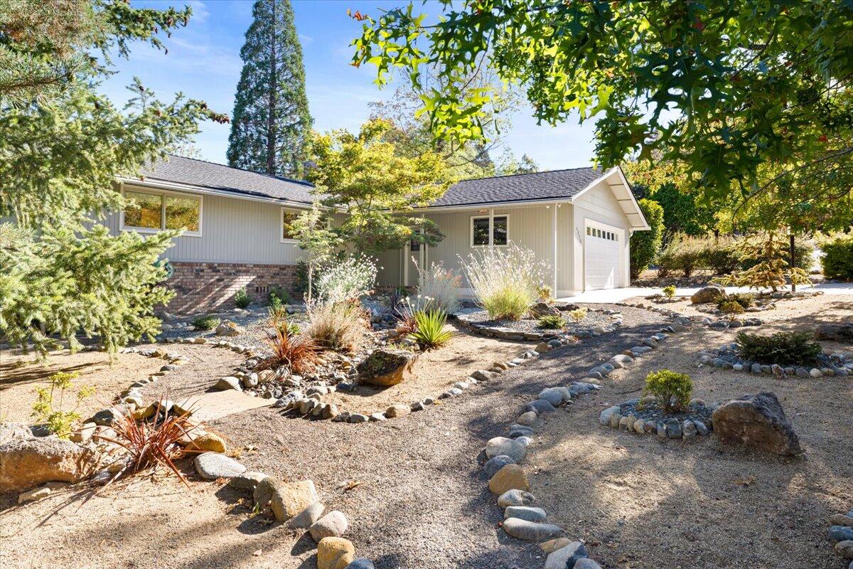 Live the easy life in this tastefully updated ranch home. Low-maintenance, drought-tolerant plantings make the yard easy-care and water-efficient, while many energy-efficient upgrades keep your utility bills low! A $45,000 solar power system, heat pump water heater and whole-house fan will keep you comfortable in all seasons at little cost. A recent remodel made the living room light and bright, with new windows and a stylish gas fireplace with built-in bookshelves. Bamboo flooring flows from the living room into the dining room. The open chef's features a pro-style stainless steel cooktop and hood and Corian countertops. A sunroom brings light into the living areas and adds a bright and welcoming extra living space. Spacious decks off the living areas and primary suite add three-season space for al fresco dining or relaxing outdoors. Hikers will love the Mountain Ranch neighborhood's community park and walking paths that connect to Ashland's extensive trail system.