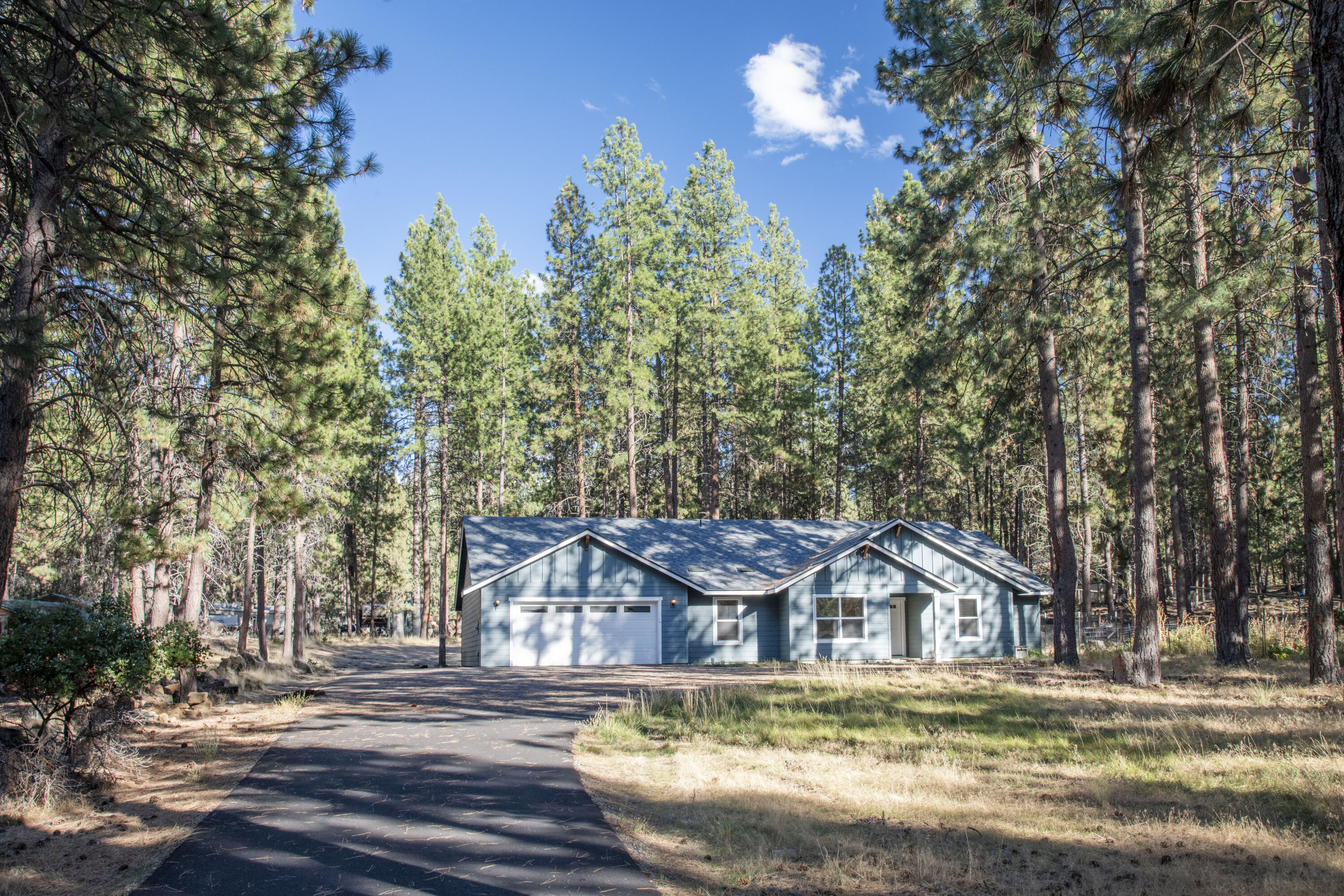 This nearly new, single-level home offers 1,952 sq. ft. of well-designed living space on a full acre in a peaceful neighborhood. Designed with comfort and functionality in mind, the open-concept living area is enhanced by vaulted ceilings, creating a bright and airy feel. The spacious primary suite serves as a private retreat with a generous bathroom featuring a soaking tub, separate walk-in shower, and walk-in closet. An office plus 2 additional bedrooms provide versatile space for guests, a home office, or hobbies. The expansive lot allows ample room for RV parking, a boat, or other recreational toys, while the outdoor setting ensures privacy and a natural buffer from neighbors. A tandem three-car garage adds even more flexibility, perfect for a workshop or extra storage.