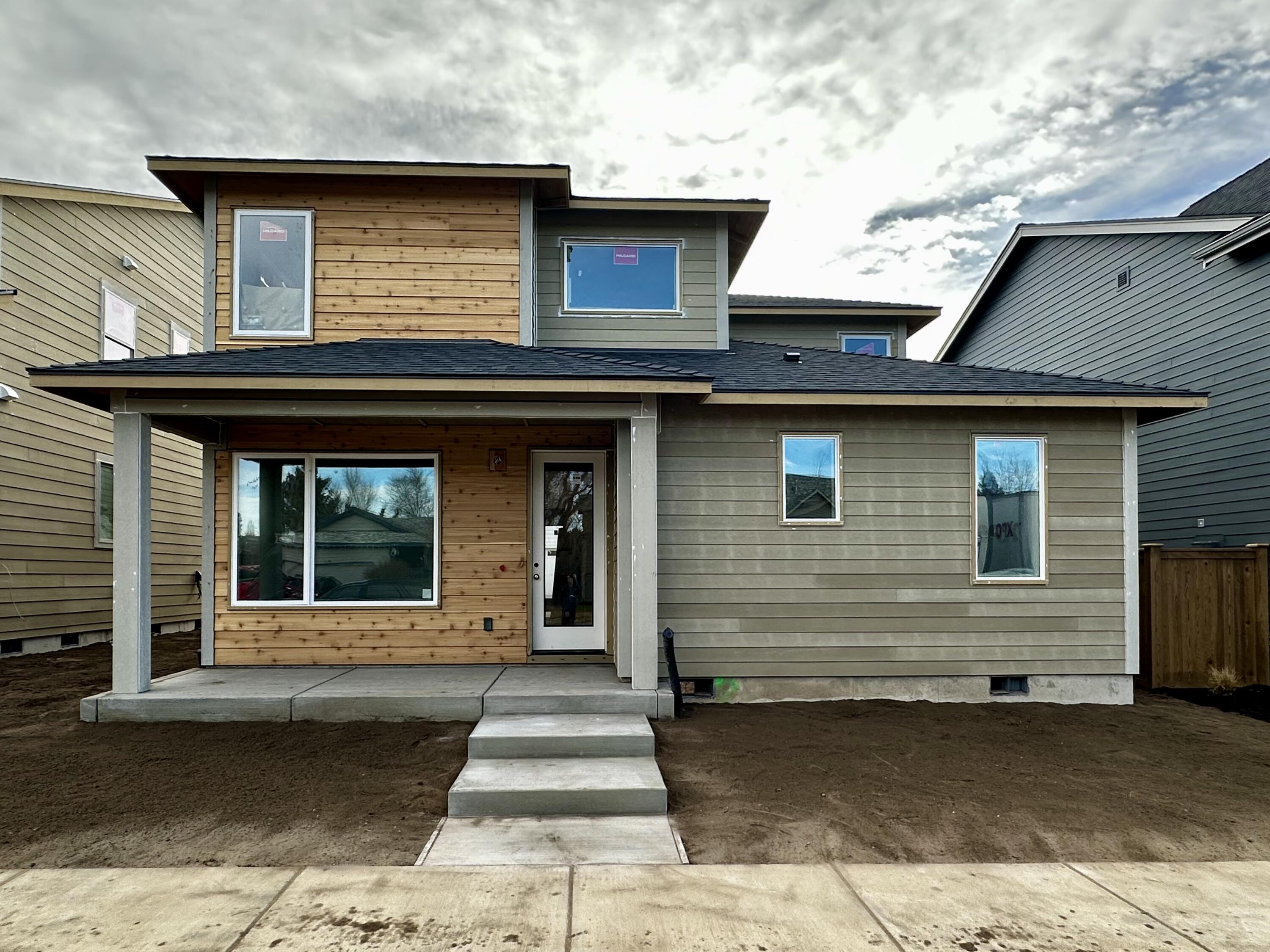 Welcome to this beautiful new construction home in Sky Vista by Stone Bridge Homes NW! The inviting covered porch leads into a bright, open-concept layout. The main-level primary suite offers comfort and style with a tiled shower, dual vanities, and spacious walk-in closet. Enjoy gathering in the great room with a gas fireplace, seamlessly connected to the kitchen featuring a large island, ample counter space, and abundant cabinetry. The utility room conveniently connects to the alley-load garage. Upstairs includes four bedrooms plus an optional fifth bedroom or den, a full bath with dual vanities, and a versatile loft space perfect for work or play. Outside, the home is fully fenced and landscaped, creating a private outdoor retreat ready for entertaining or relaxation. Thoughtfully designed with quality craftsmanship and modern finishes throughout!