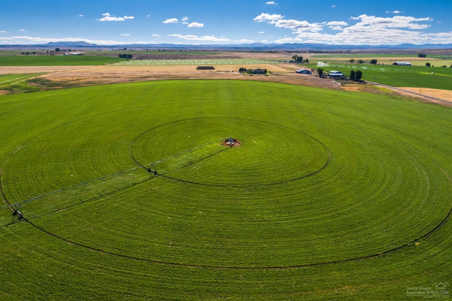 Madras Farm with Cascade Mountain views and private location. 178.31 acres with 168.4 acres of North Unit irrigation water rights. Farm includes 2 pivots, wheel lines and hand lines, barn with runs, shop, hay barn, machine shed with storage room/tack room and covered corral with cattle handling equipment. Ranch home is 2674 sf, 3 bedrooms, 2.5 baths, open floor plan, granite countertops, hickory cabinets, family room, fireplace, utility room, attached 2 car garage, landscaped. Shown by appointment.