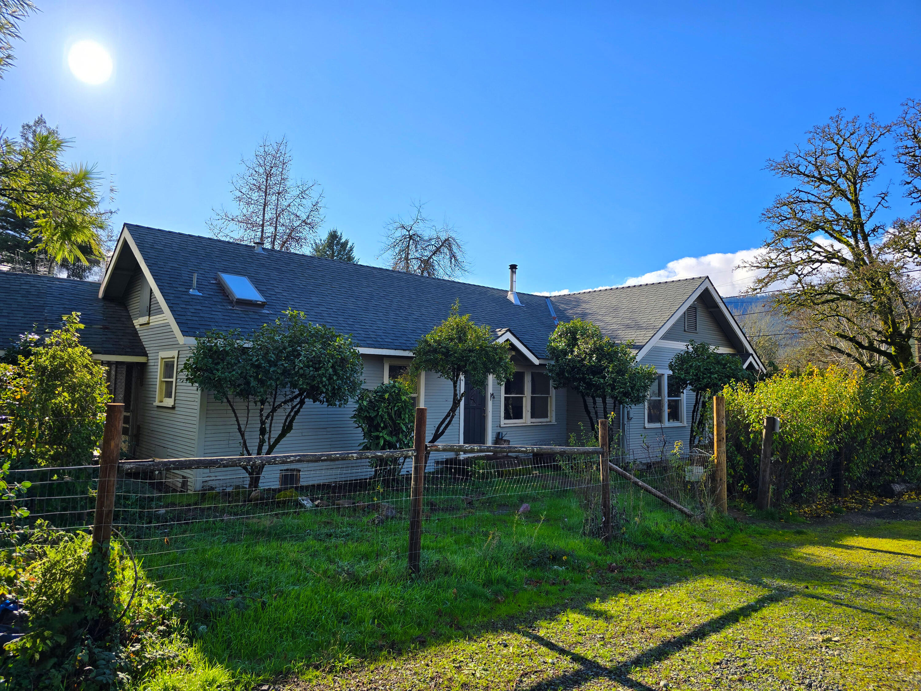 Discover a hidden gem on Redwood Hwy! This small lot feels much larger thanks to lush, established landscaping from a master gardener—featuring rare and exotic plants throughout. Ideal for a hobby farm, private garden retreat, or restoring to its former glory. Enjoy a spacious shop built for an RV, plus an extra workshop for projects or storage. RC (Rural Commercial) zoning offers fantastic flexibility for residential or business use. Interior photos coming soon as we wrap up finishing touches and fresh paint—home is in solid condition and full of potential. Don't miss this unique opportunity to own a slice of Southern Oregon paradise with endless possibilities!