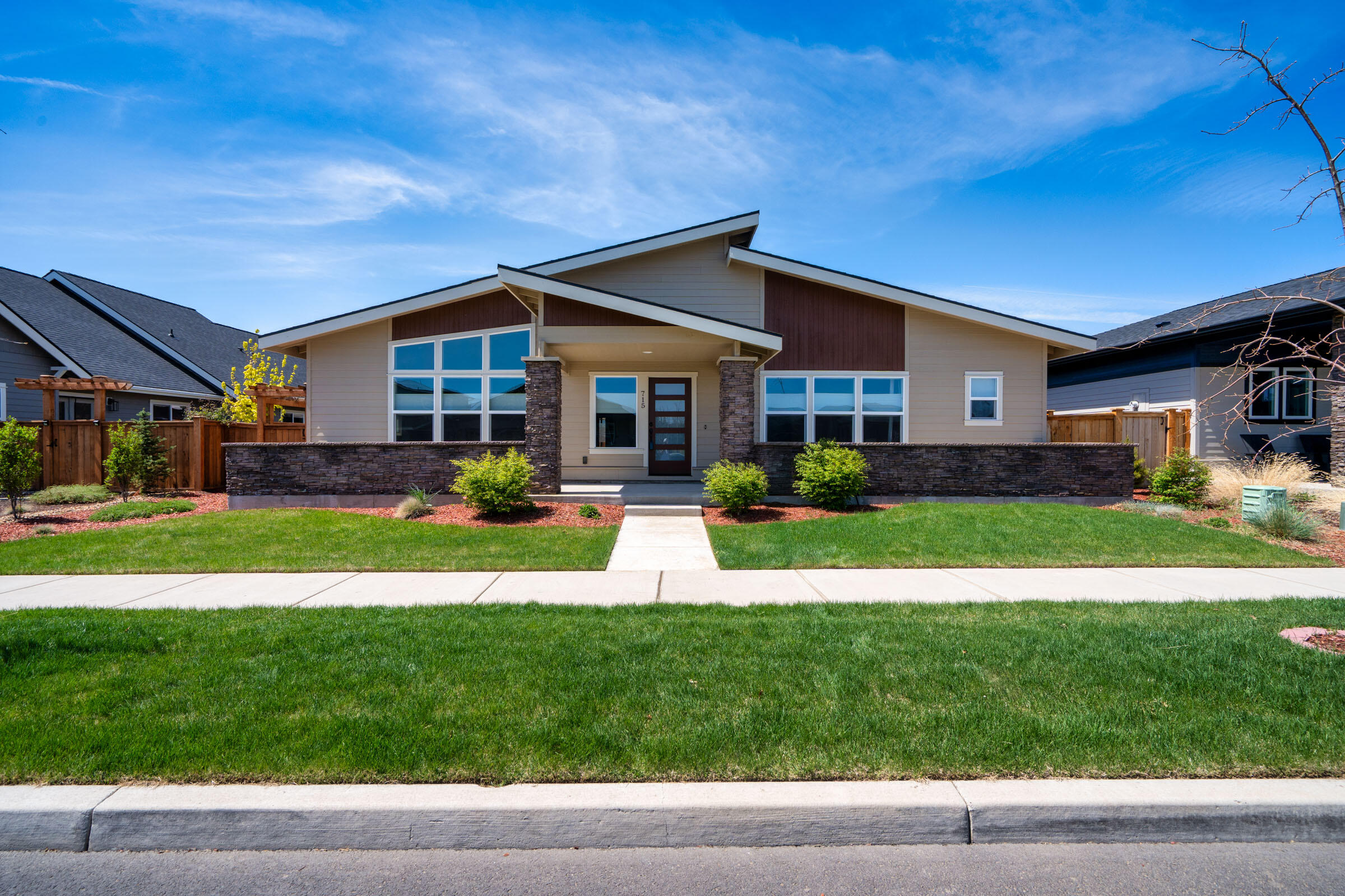 Steps from Redmond's scenic Dry Canyon, modern design meets quality craftsmanship. Open and inviting layout offers spacious living area and oversized bedrooms. The Great Room features a tile surround fireplace. Attractive kitchen touts a breakfast bar, quarts slab countertops, full height backsplash and stainless steel appliances, including a gas range and farmhouse sink, and pantry. The primary suite showcases a walk-in, walk through closet that leads into an adjacent office for dedicated flexible workspace. Ensuite bathroom features a step-in shower and dual vanities. Two additional guest bedrooms share a well-appointed full bath. The large laundry room has a utility sink and lots of storage. The lot is fully fenced with alley access to the spacious three car garage. The backyard pergola has adjustable louvers and retractable screens for additional privacy.